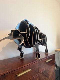 Schwarze dekorative Elefantenfigur aus Holz steht auf einer braunen Kommode.