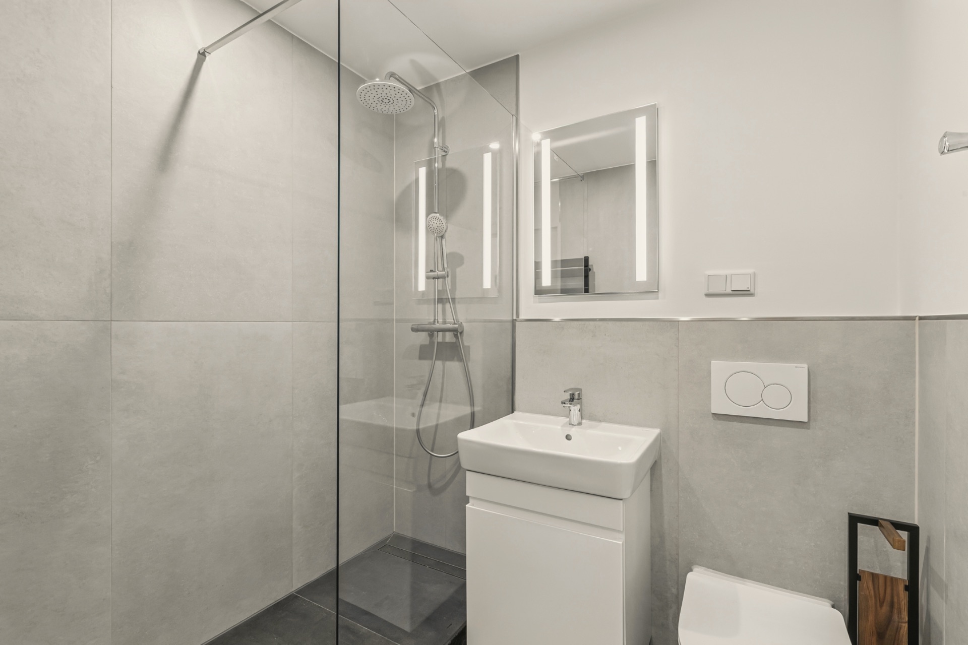 Modernes Badezimmer mit Dusche, Waschbecken, Spiegel und Toilette.