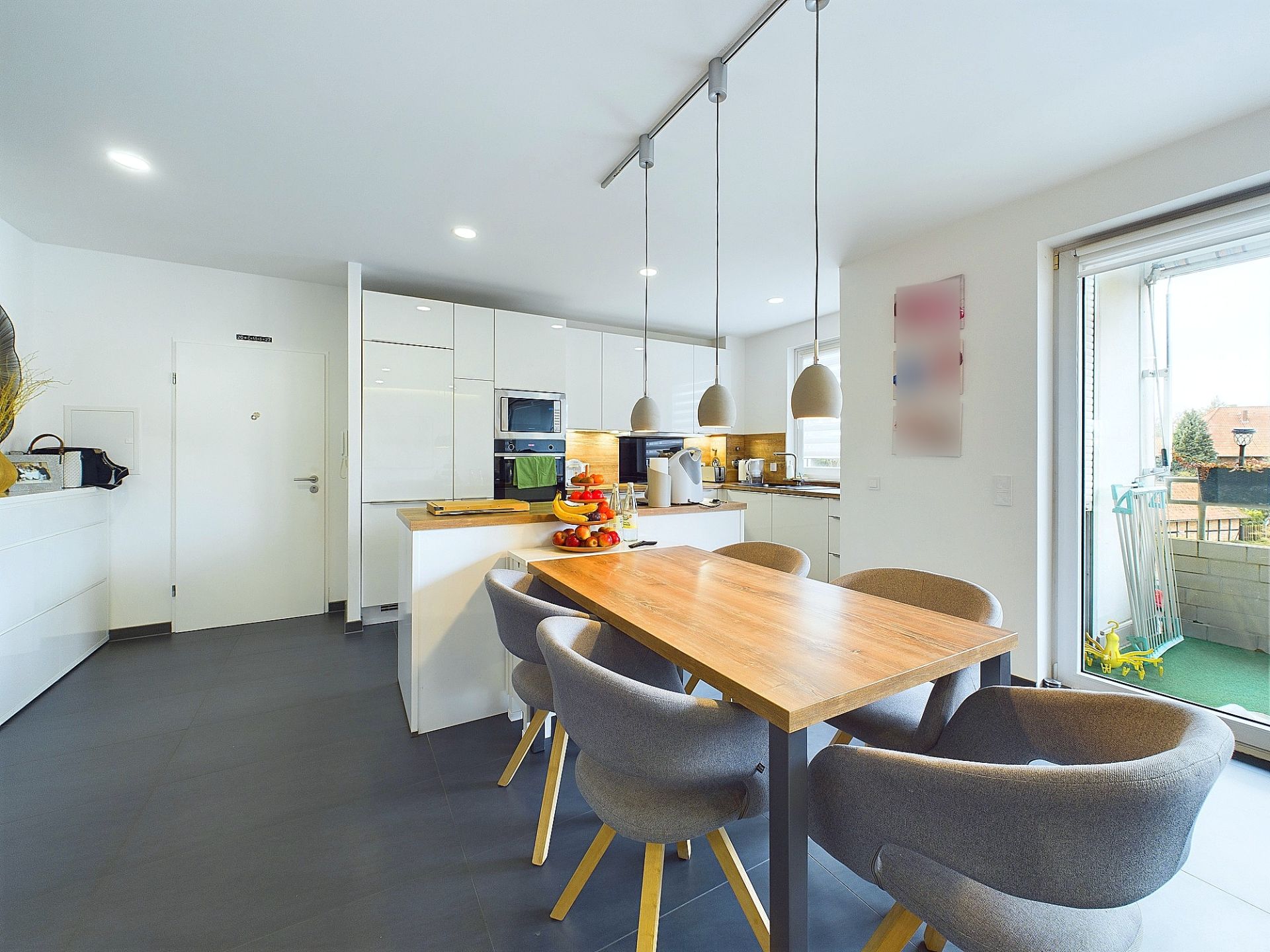 Moderne Küche mit Esstisch, sechs Stühlen und Zugang zum Balkon.