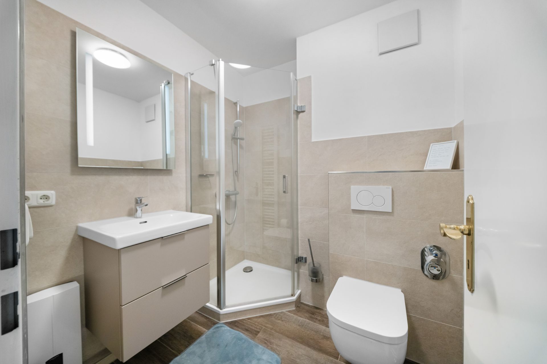 Modernes Badezimmer mit Dusche, Waschbecken, Spiegel und Toilette.