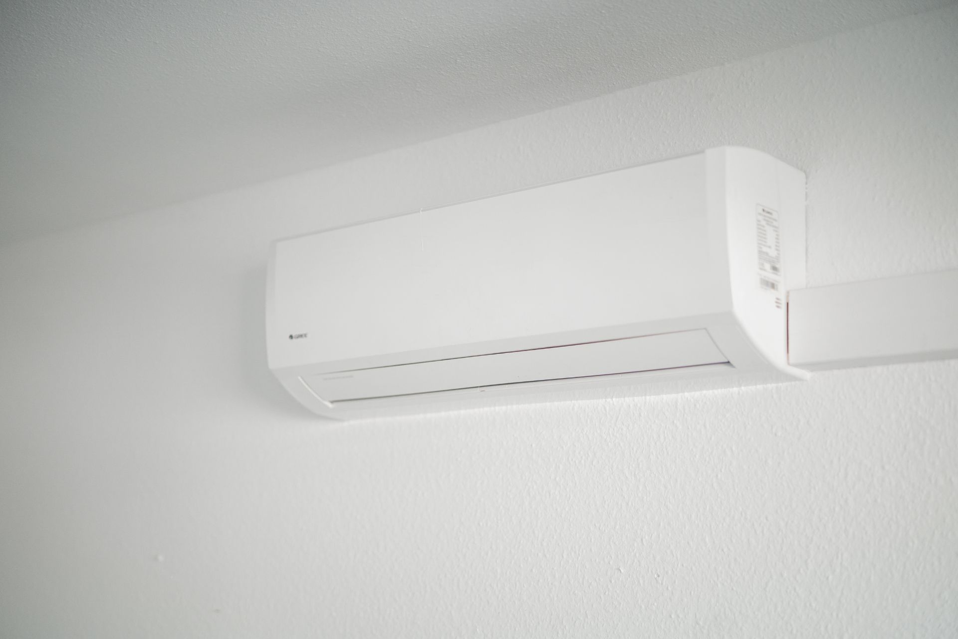 Weiße Klimaanlage ist an einer weißen Wand in einem Raum montiert.
