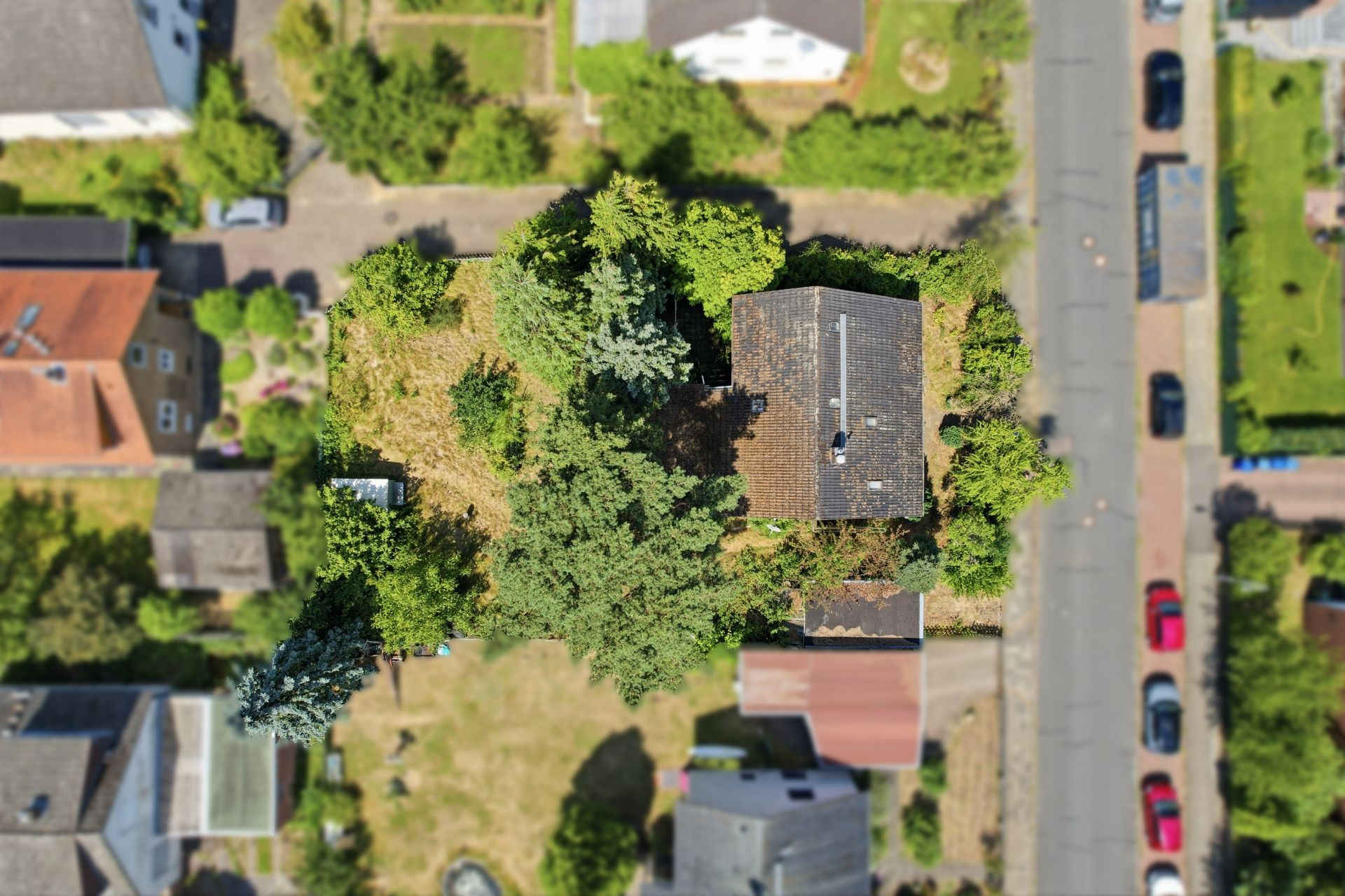 Luftaufnahme eines Wohnhauses mit Garten und umliegenden Straßen.