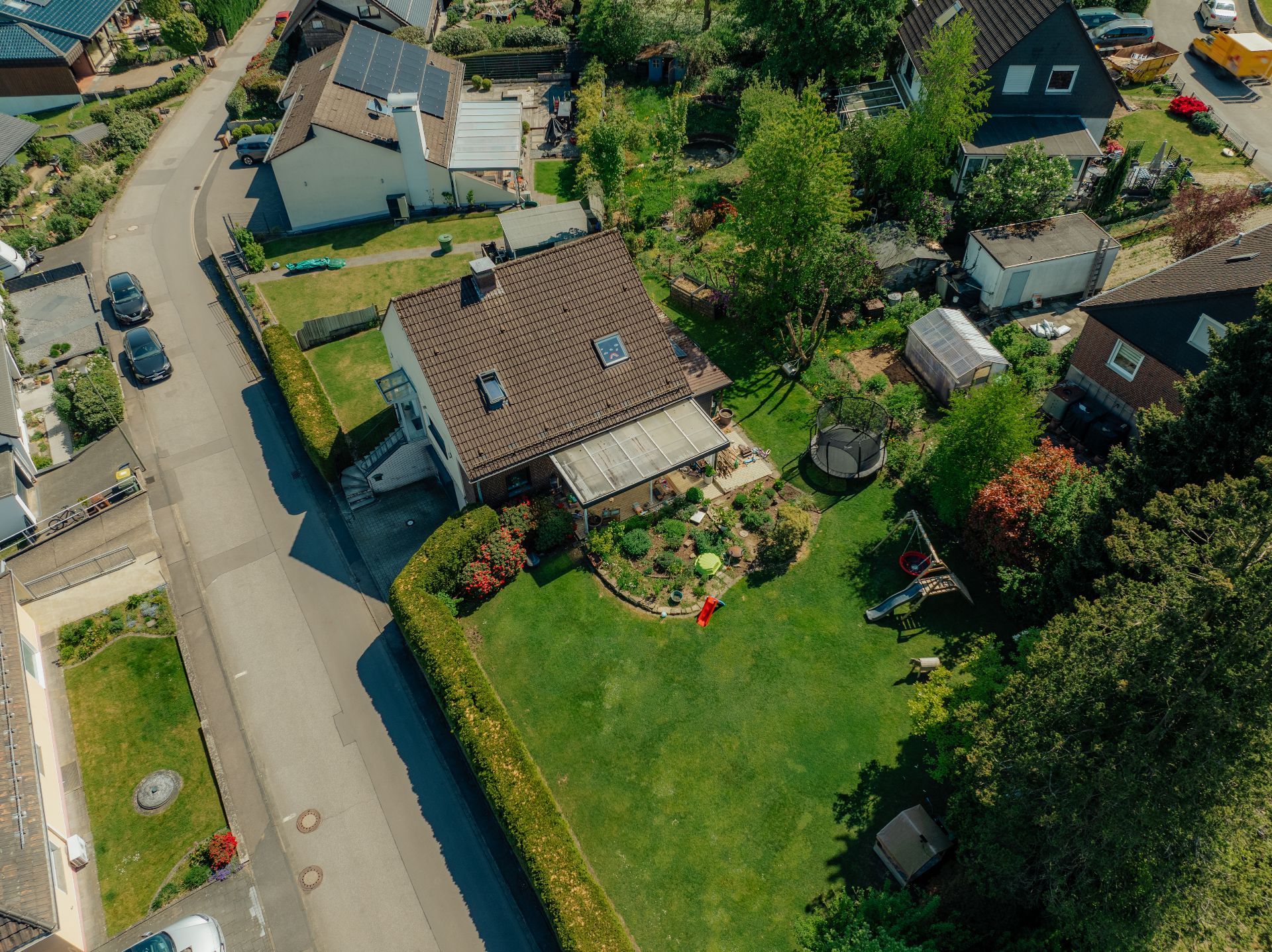 Luftaufnahme eines Hauses mit Garten und Rasenfläche in einer Wohnsiedlung.