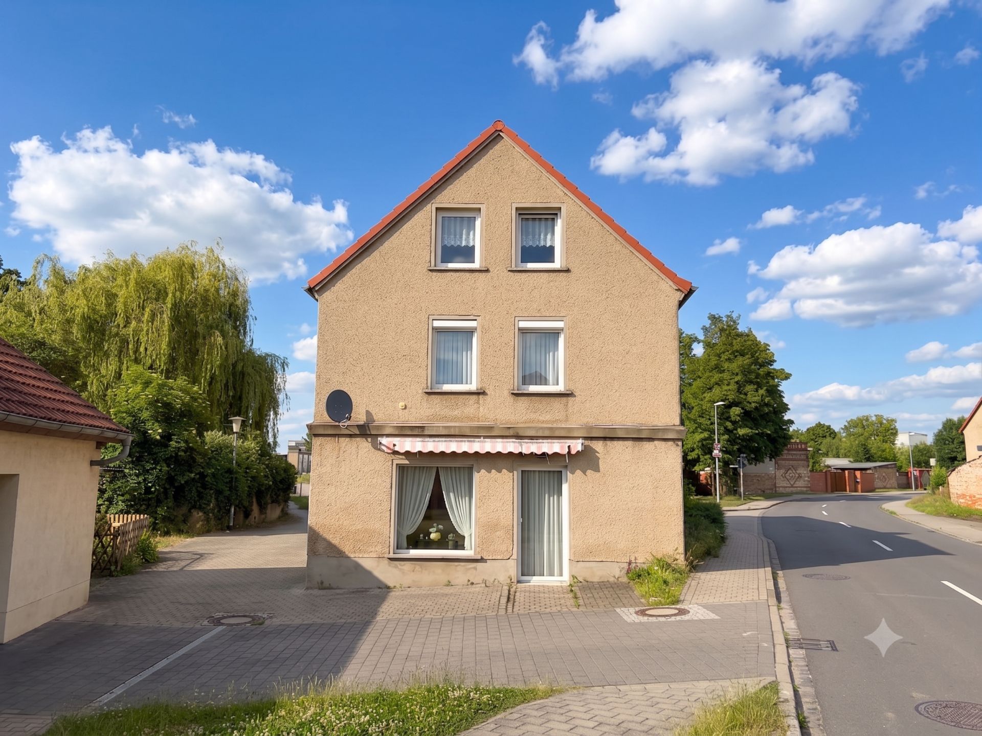 Zweistöckiges Wohnhaus mit Satteldach und fünf Fenstern an einer ruhigen Straße.