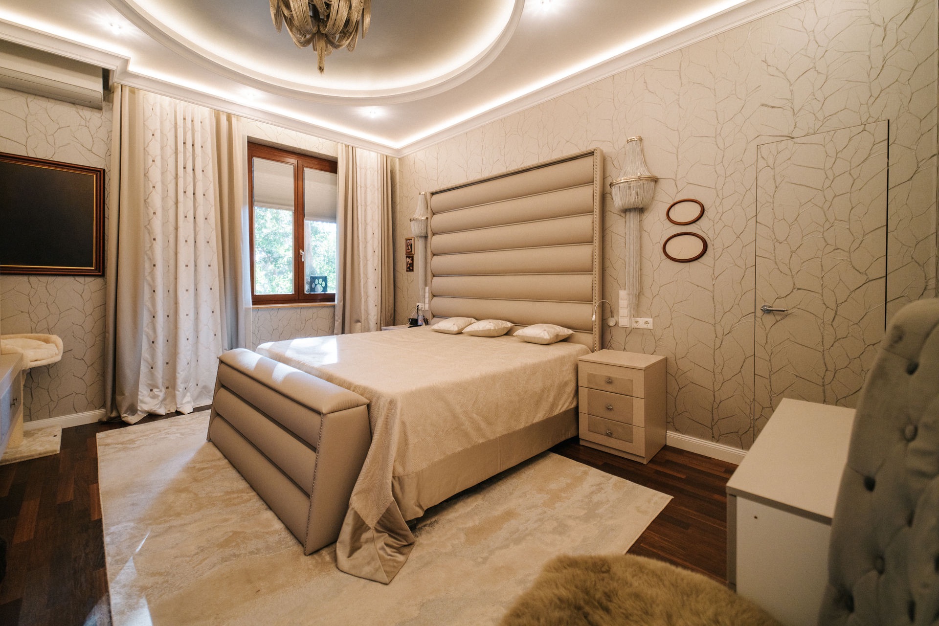 Modern eingerichtetes Schlafzimmer mit großem Bett, Fenster, Teppich und Nachttischen.