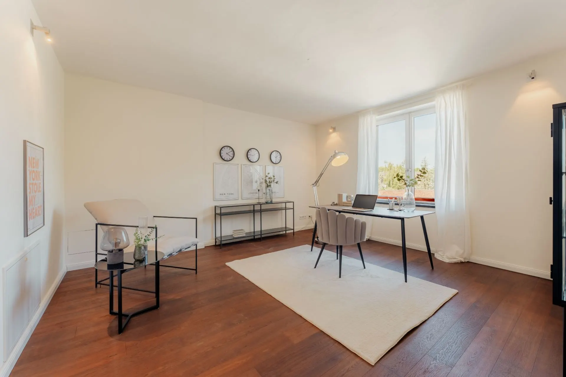 Helles Arbeitszimmer mit Holzfußboden, Schreibtisch am Fenster und moderner Dekoration.