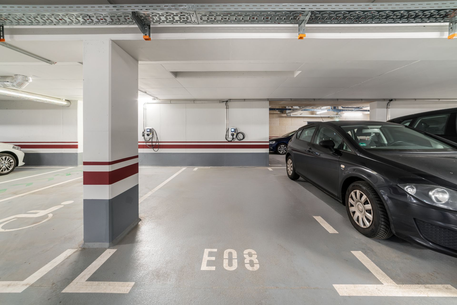 Tiefgaragenstellplatz mit Ladesäulen für Elektroautos und parkenden Fahrzeugen.