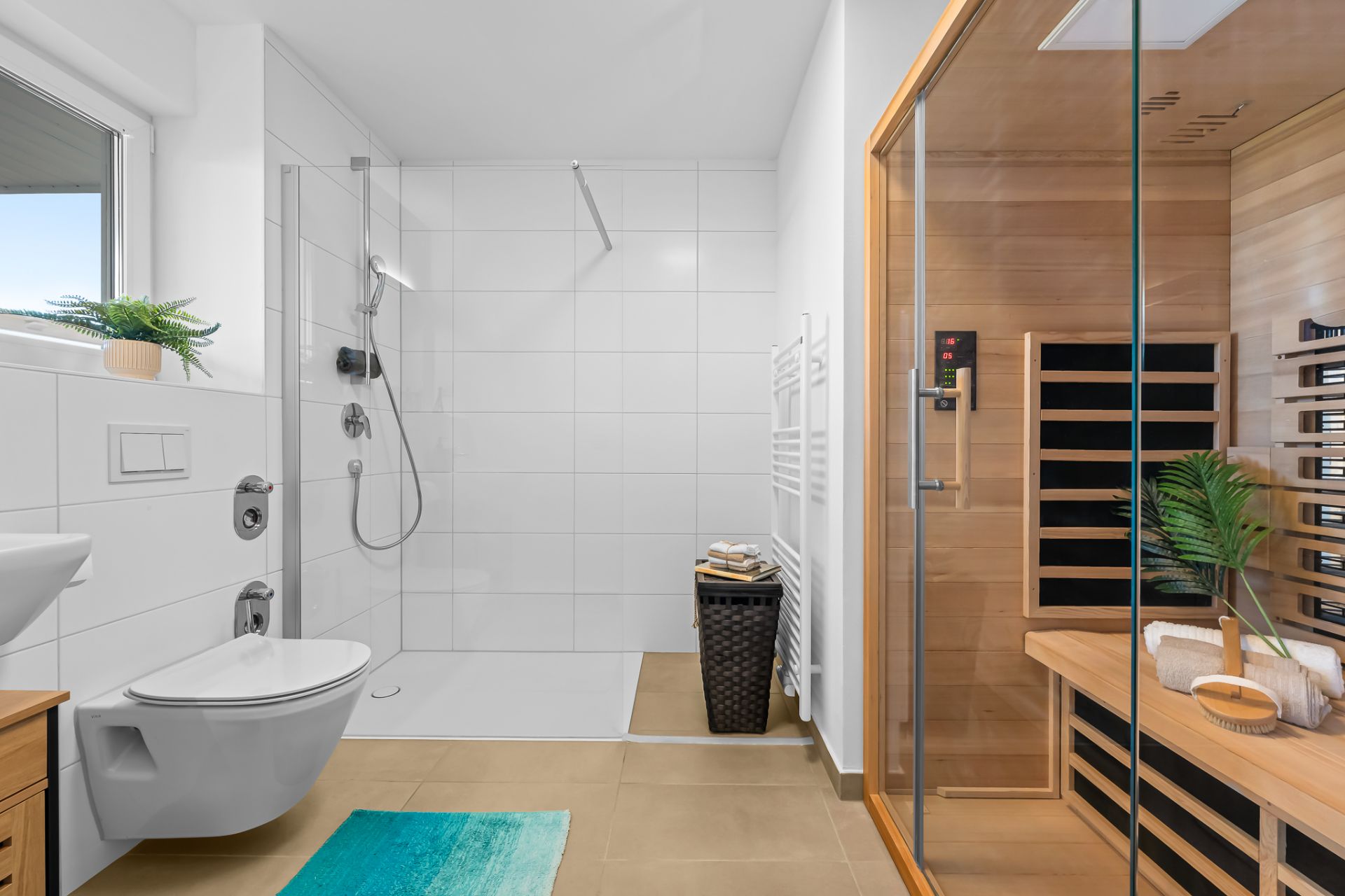Modernes Badezimmer mit Dusche, Sauna, Toilette und Waschbecken, helle Fliesen und Holzelemente.