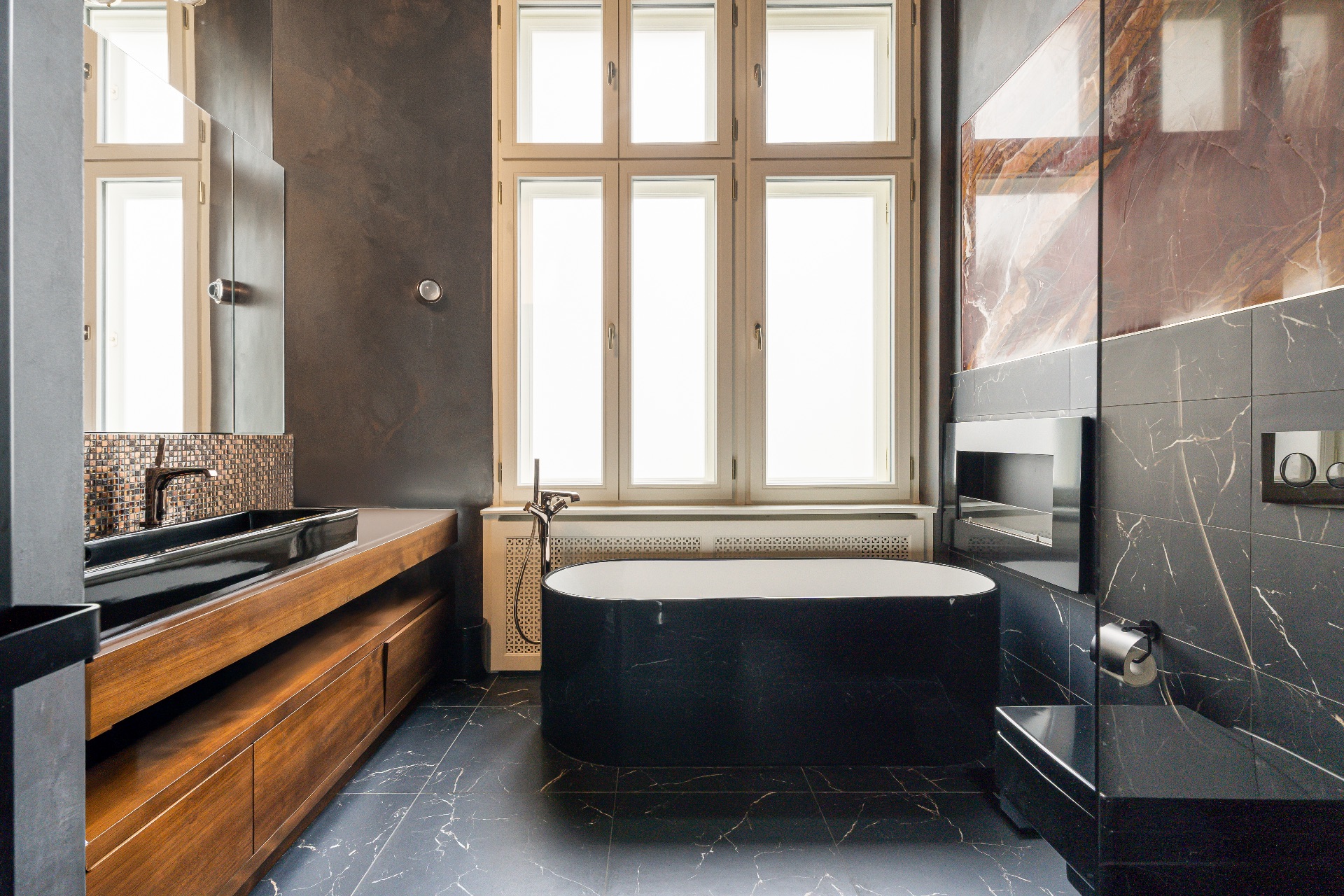 Modernes Badezimmer mit freistehender Badewanne, großem Fenster und dunklem Waschtisch.