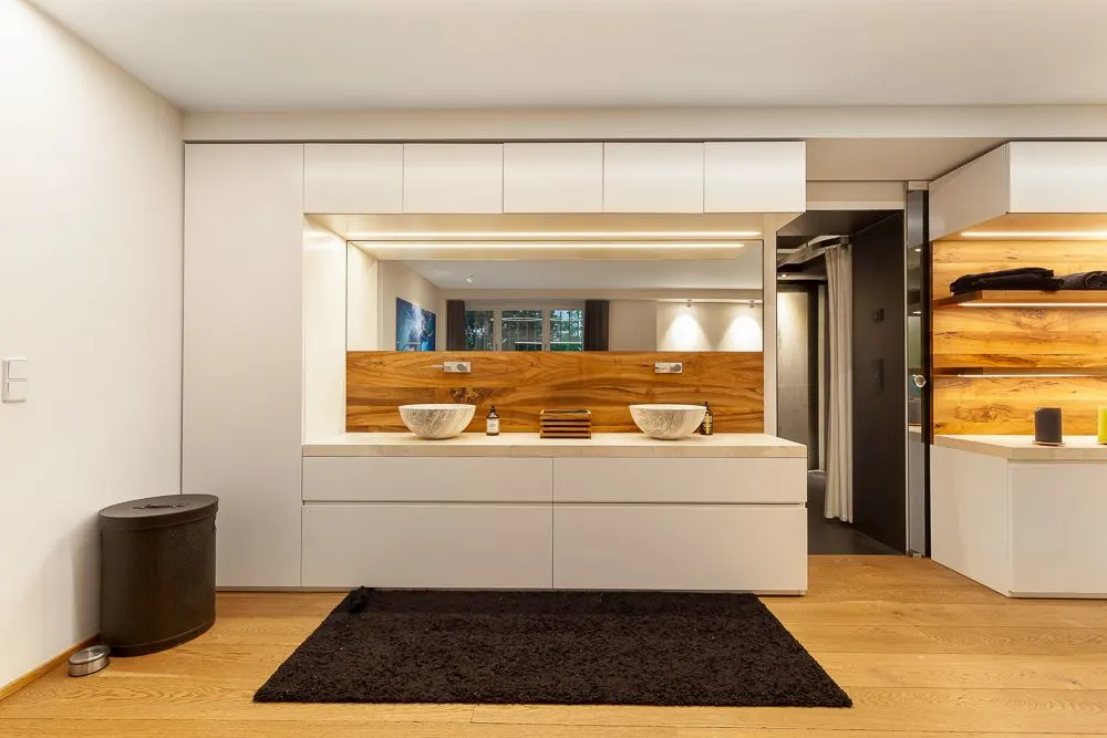 Modernes Badezimmer mit Doppelwaschbecken, großem Spiegel und Holzdetails.