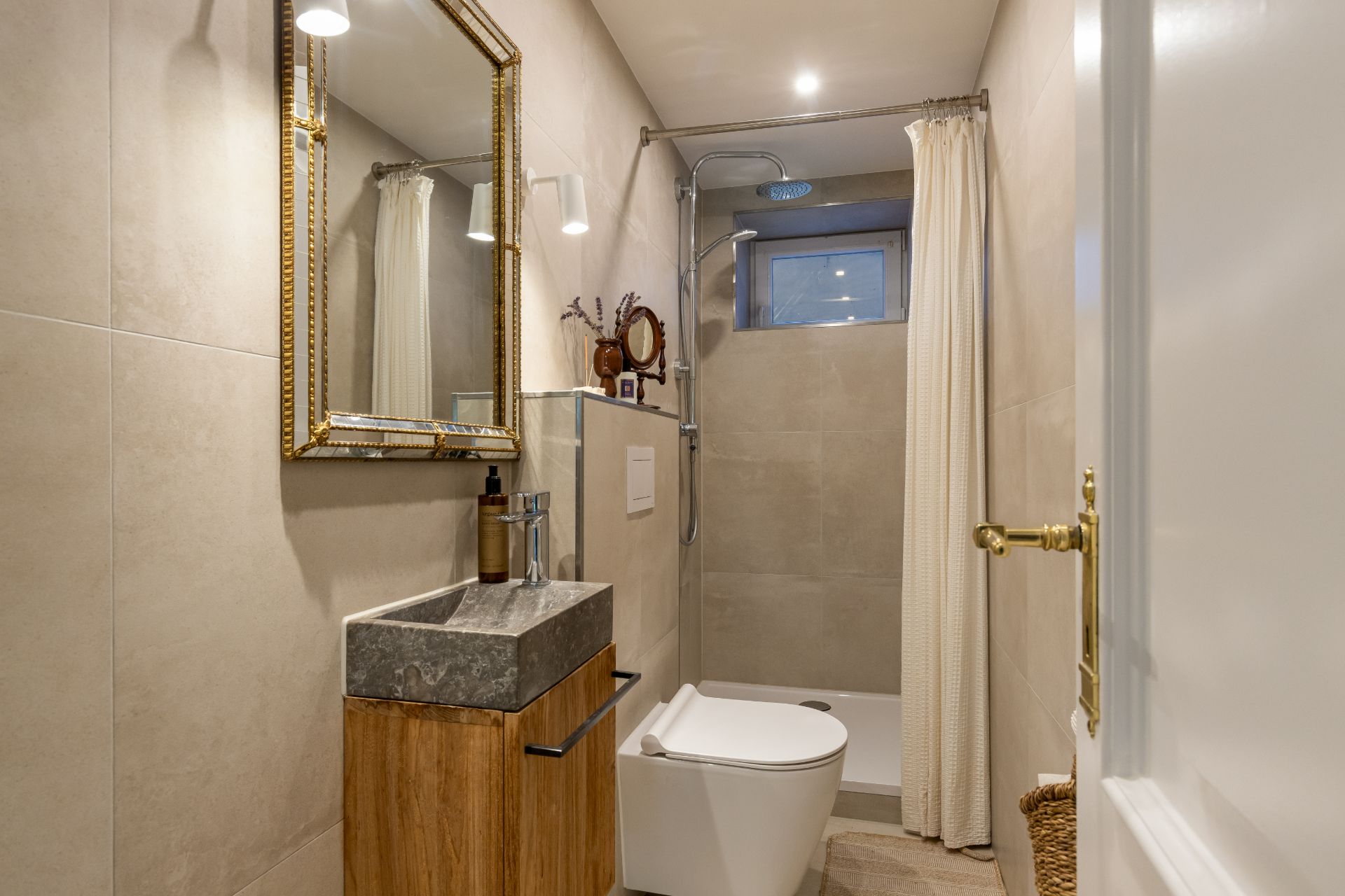 Modernes Badezimmer mit Waschbecken, Spiegel, Toilette und Dusche mit Vorhang.