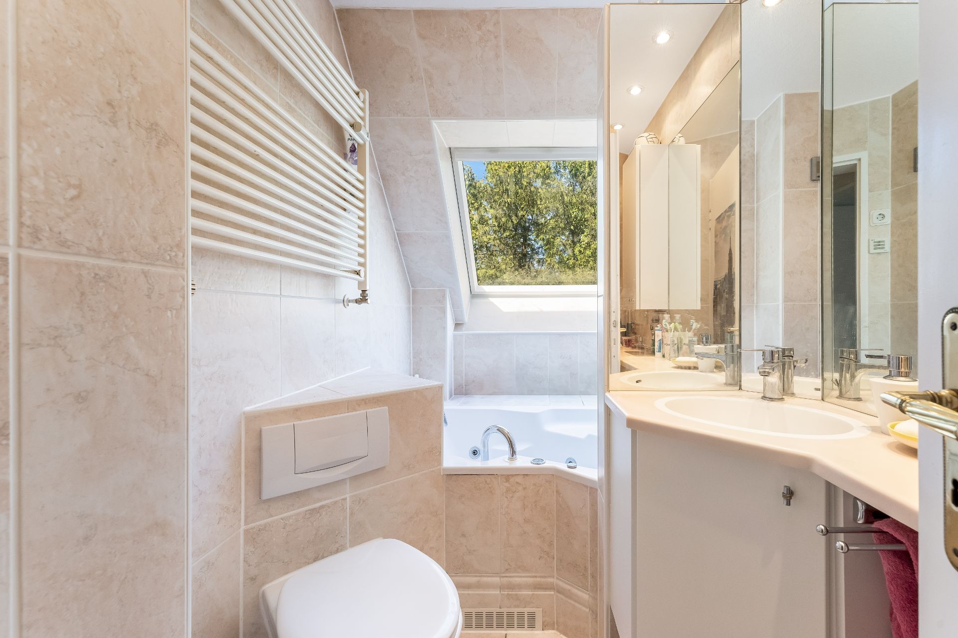 Modernes Badezimmer mit Toilette, Badewanne, Waschbecken und großem Spiegel.