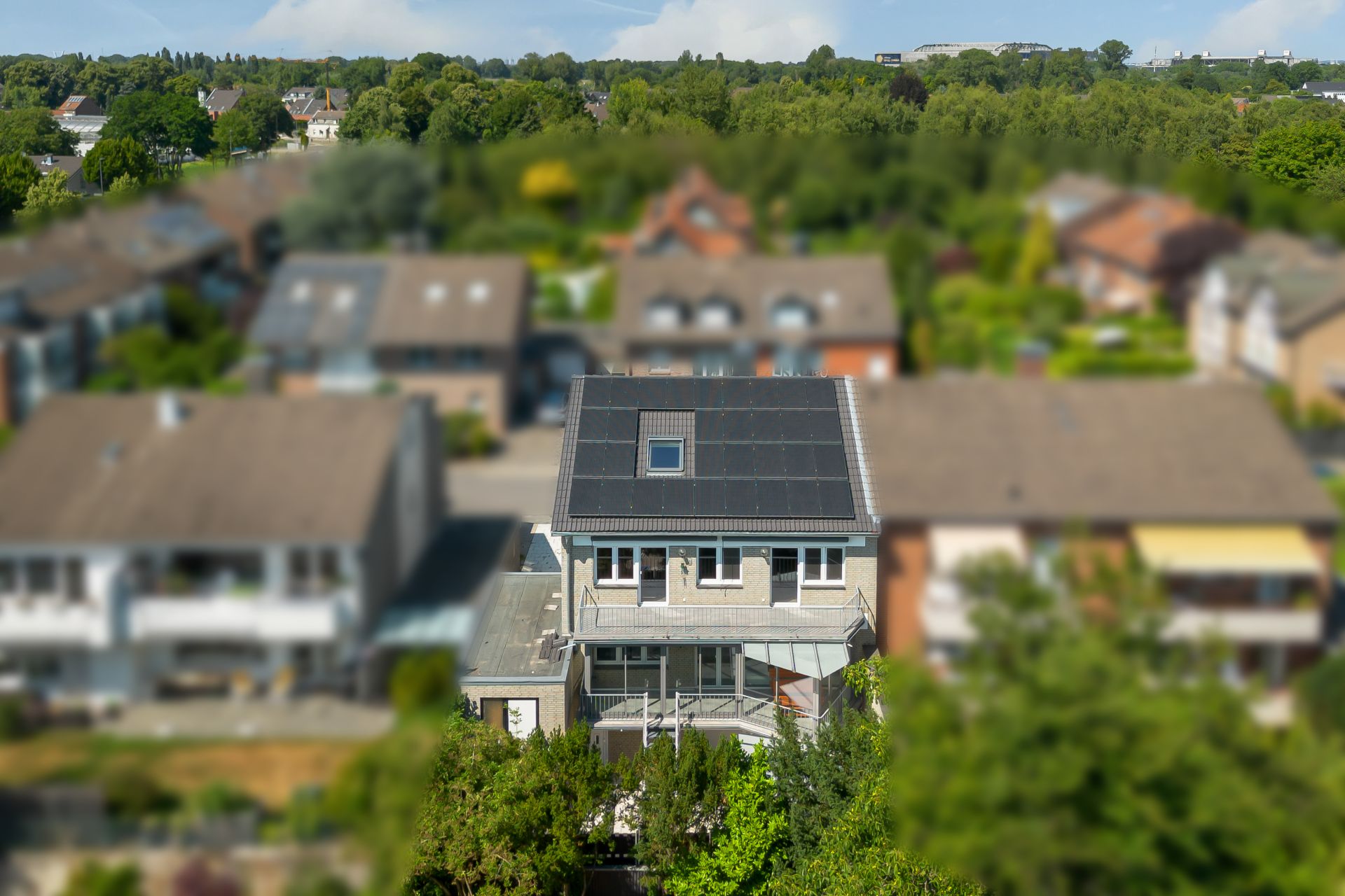 Modernes Wohnhaus mit Solarpanelen auf dem Dach in einem Wohngebiet.