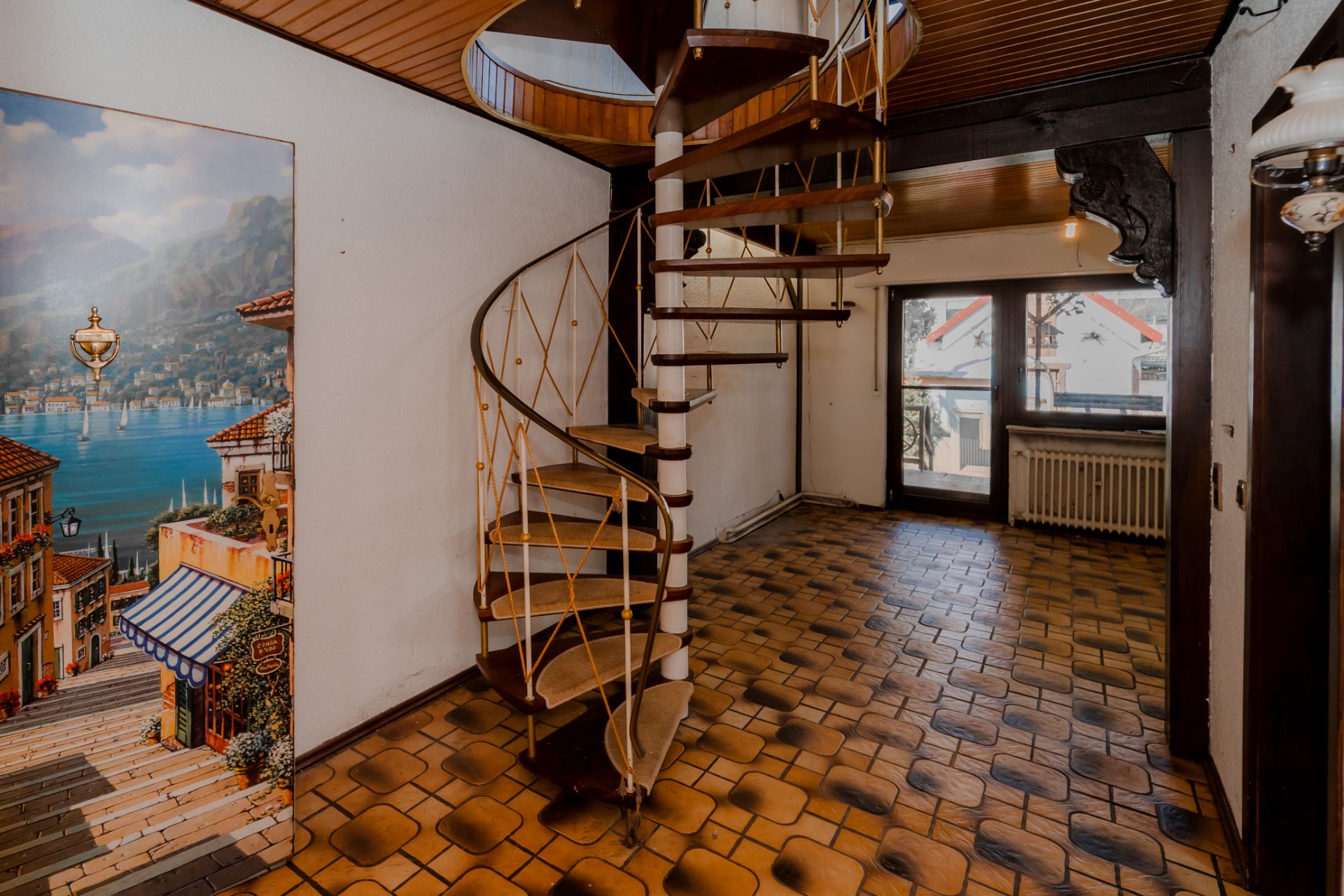 Wohnbereich mit Wendeltreppe, gemustertem Fliesenboden und großem Fenster.