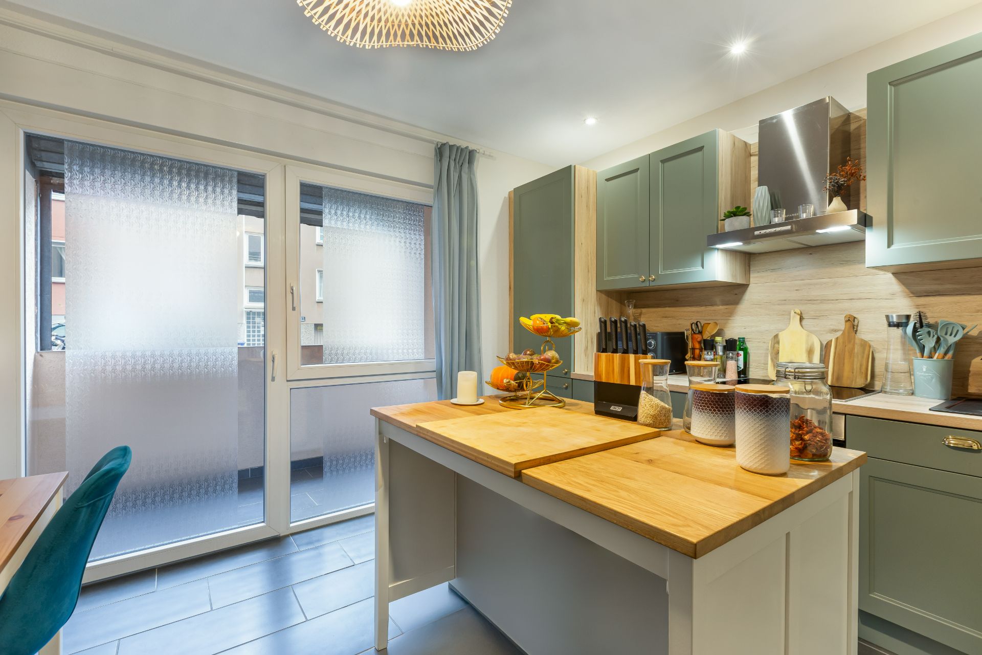 Moderne Küche mit Kücheninsel, Holzarplatten und großen Fenstern mit Milchglas.