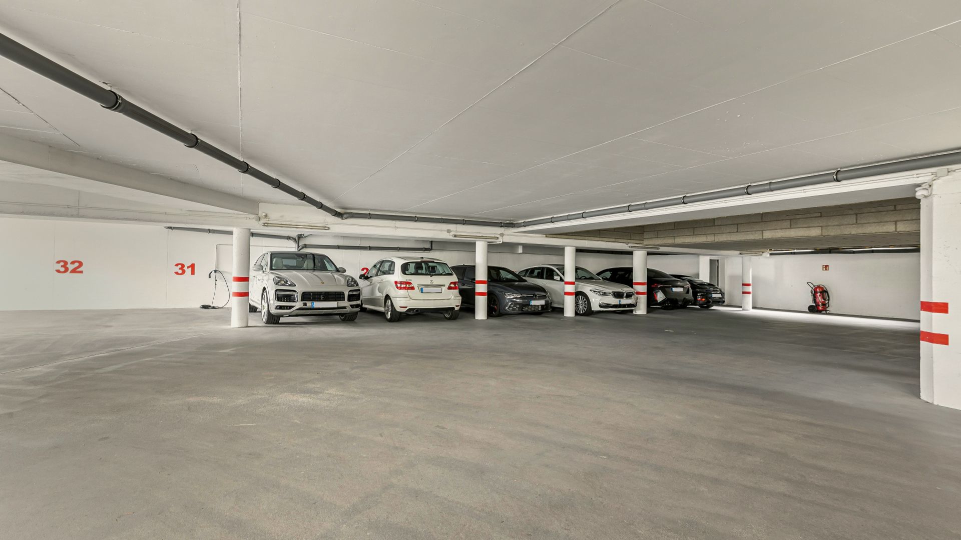 Tiefgarage mit mehreren geparkten Autos und markierten Parkplätzen.