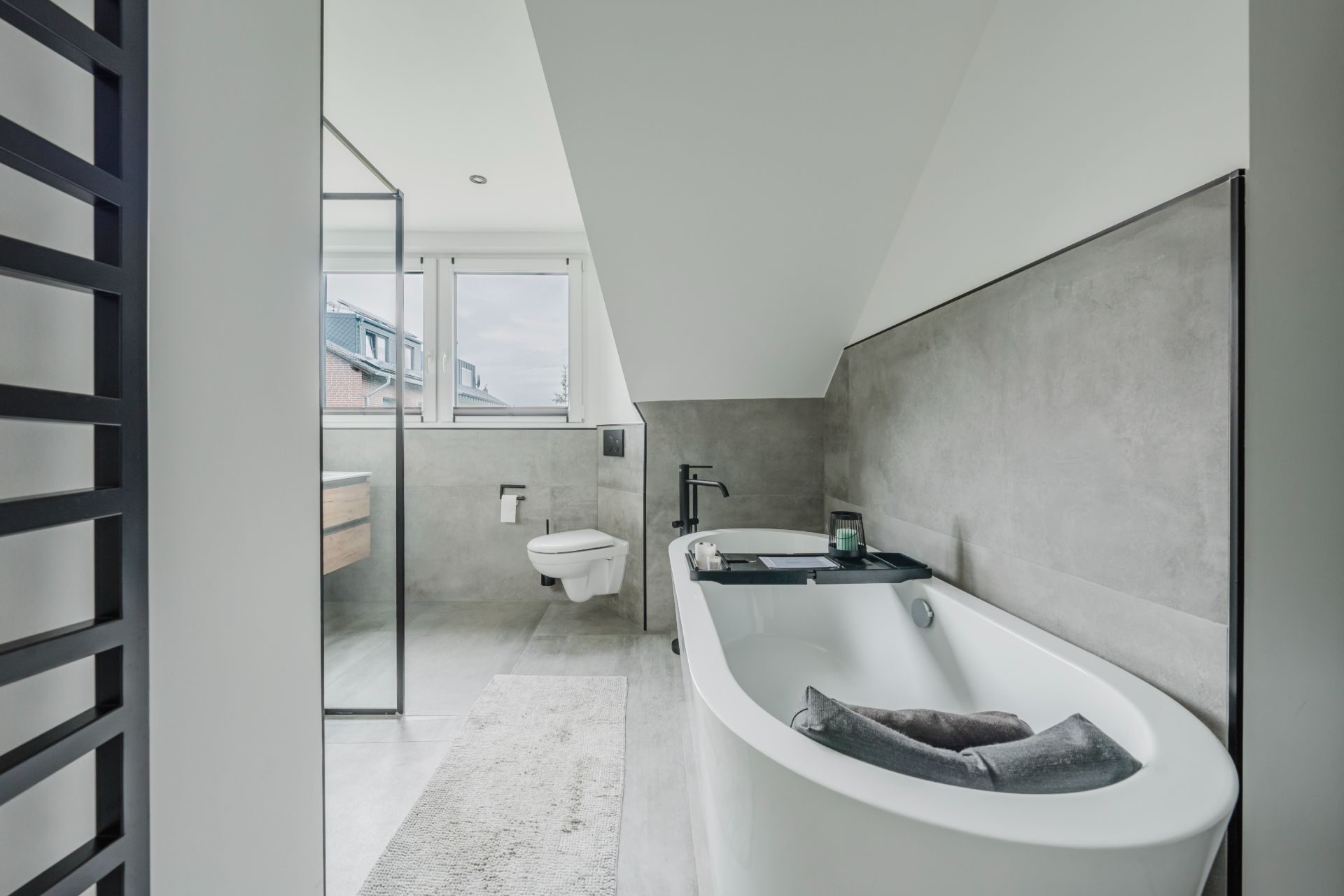 Modernes Badezimmer mit freistehender Badewanne, Dusche, WC und großem Fenster.