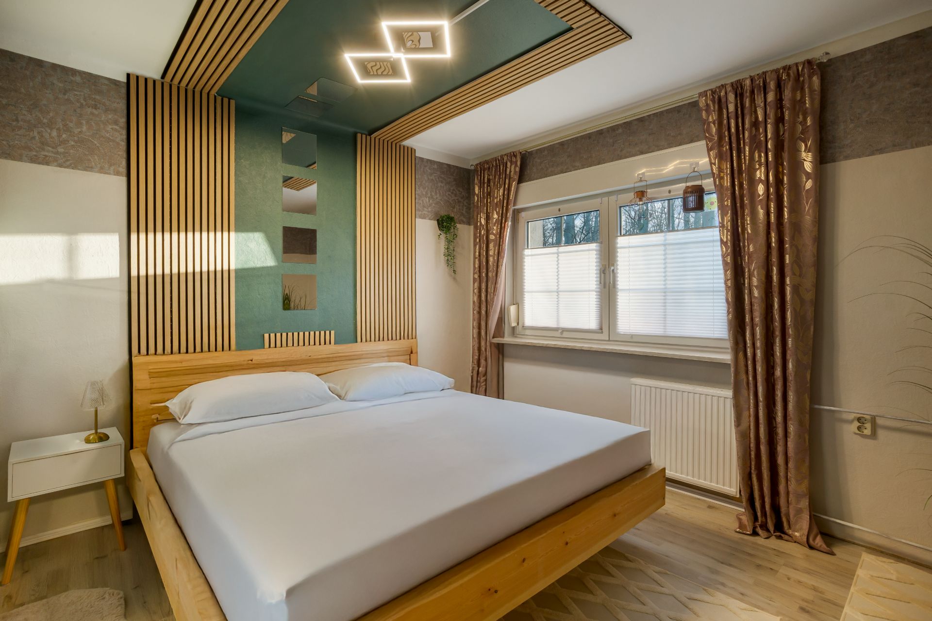 Schlafzimmer mit Holzbett, Nachttisch, großem Fenster und modernen Deckenleuchten.
