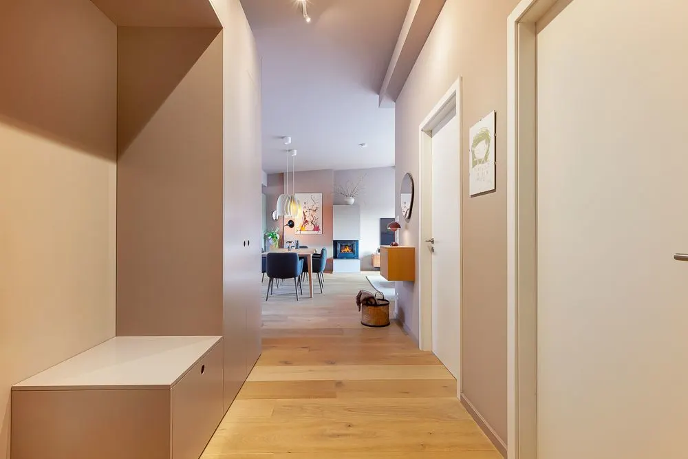 Heller Flur mit Holzboden führt in ein offenes Wohn- und Esszimmer.