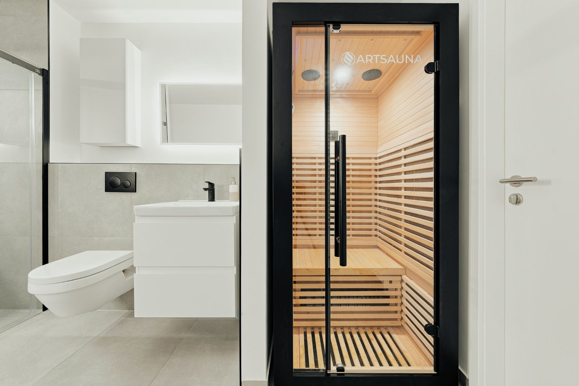 Modernes Badezimmer mit einer kleinen Sauna aus Holz und einer Duschkabine.