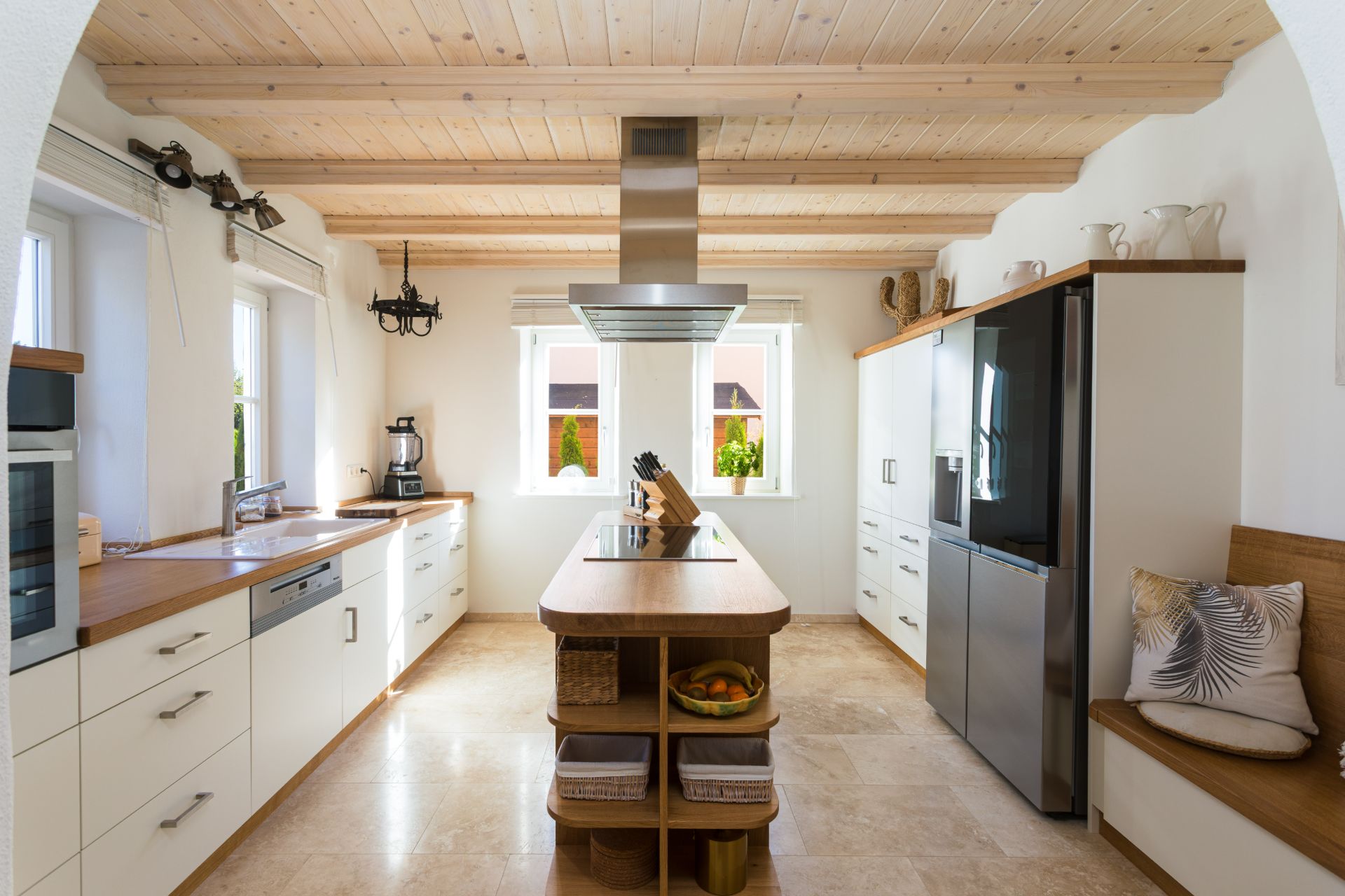 Helle, moderne Küche mit Kücheninsel, Holzdecke und großen Fenstern.