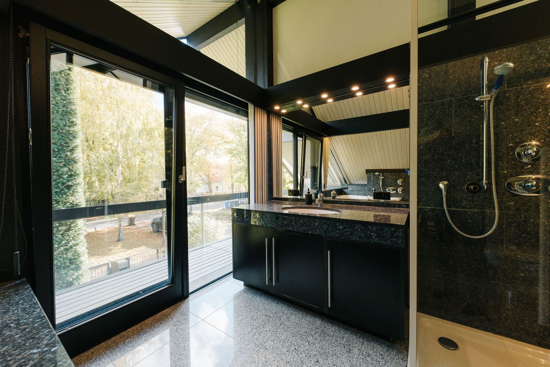 Modernes Bad mit großem Fenster, Doppelwaschbecken, Spiegel und Dusche.