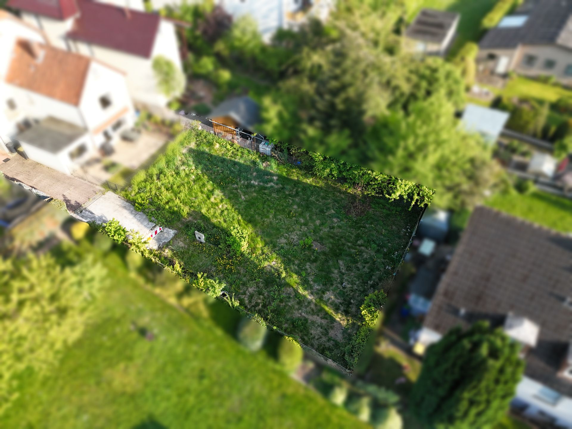 Luftaufnahme eines rechteckigen Gartens mit Wiese und Umzäunung.