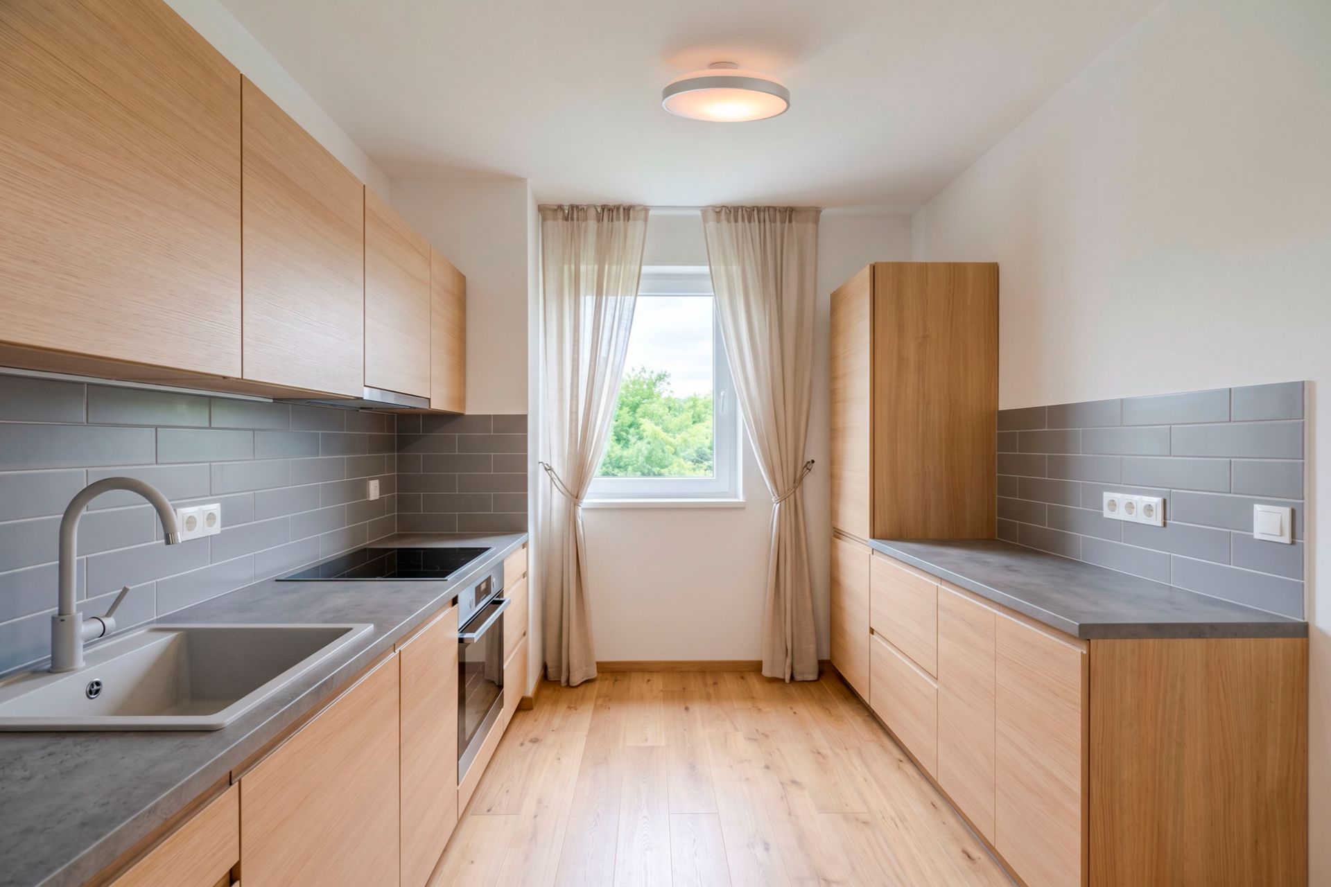 Moderne Einbauküche mit Holzfronten, grauen Fliesen und Fenster mit Vorhängen.