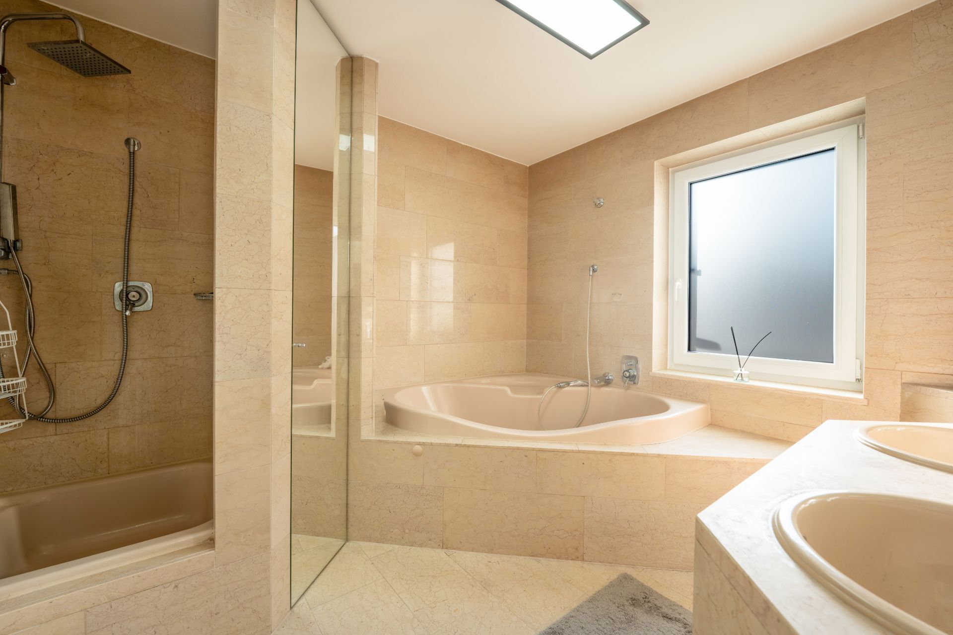Modernes Badezimmer mit Dusche, runder Badewanne und Doppelwaschbecken, großes Fenster.