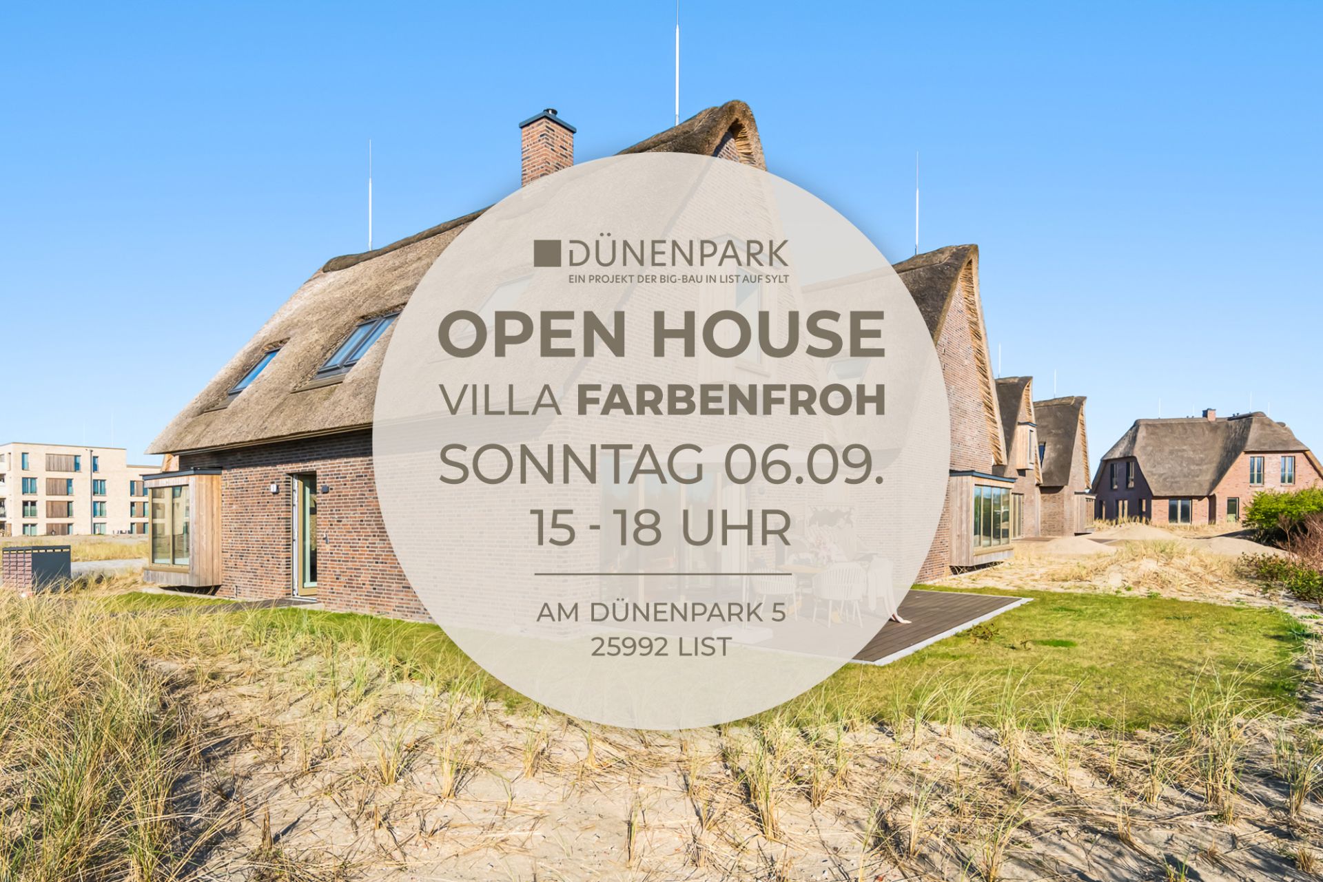 Reetgedecktes Haus mit Ziegelwänden und großen Fenstern, umgeben von Sand und Gras.