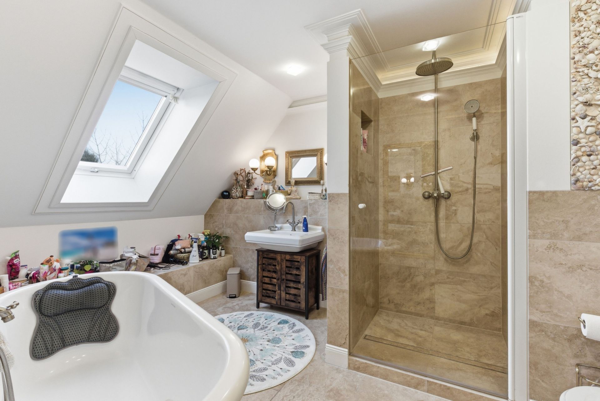 Helles Badezimmer mit Badewanne, Dusche, Waschbecken und Dachfenster.