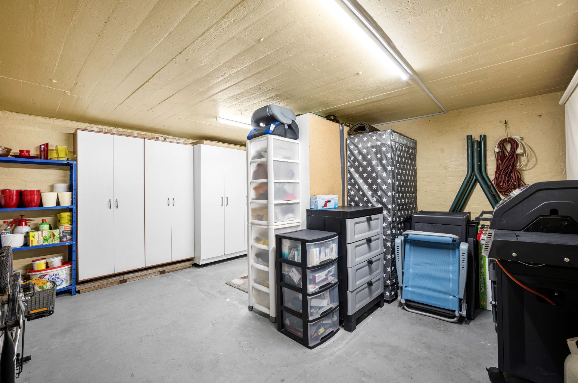Kellerraum mit mehreren Schränken, Regalen und verschiedenen Aufbewahrungsboxen.