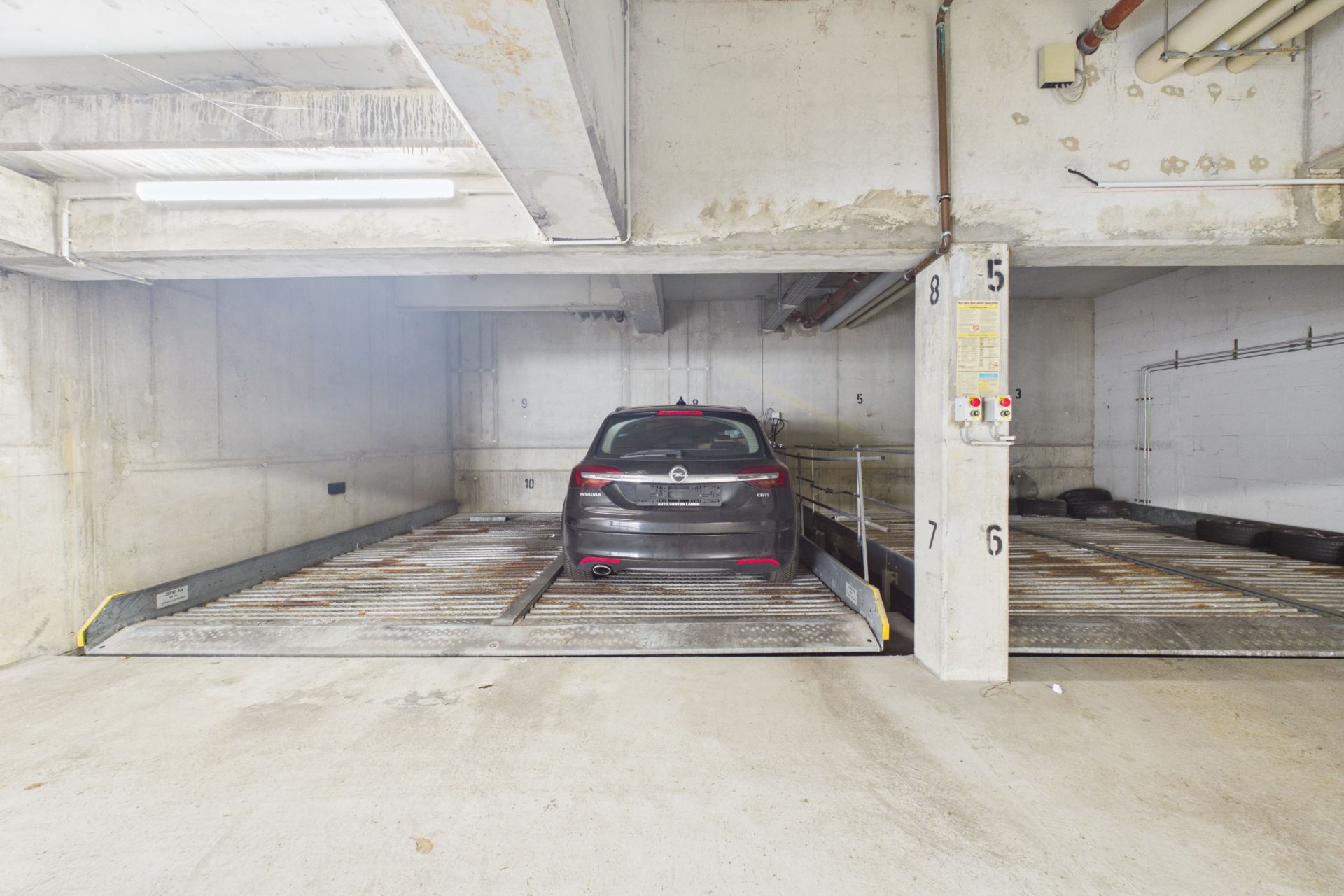 Auto parkt in einer Tiefgarage auf einem metallenen Parksystem.
