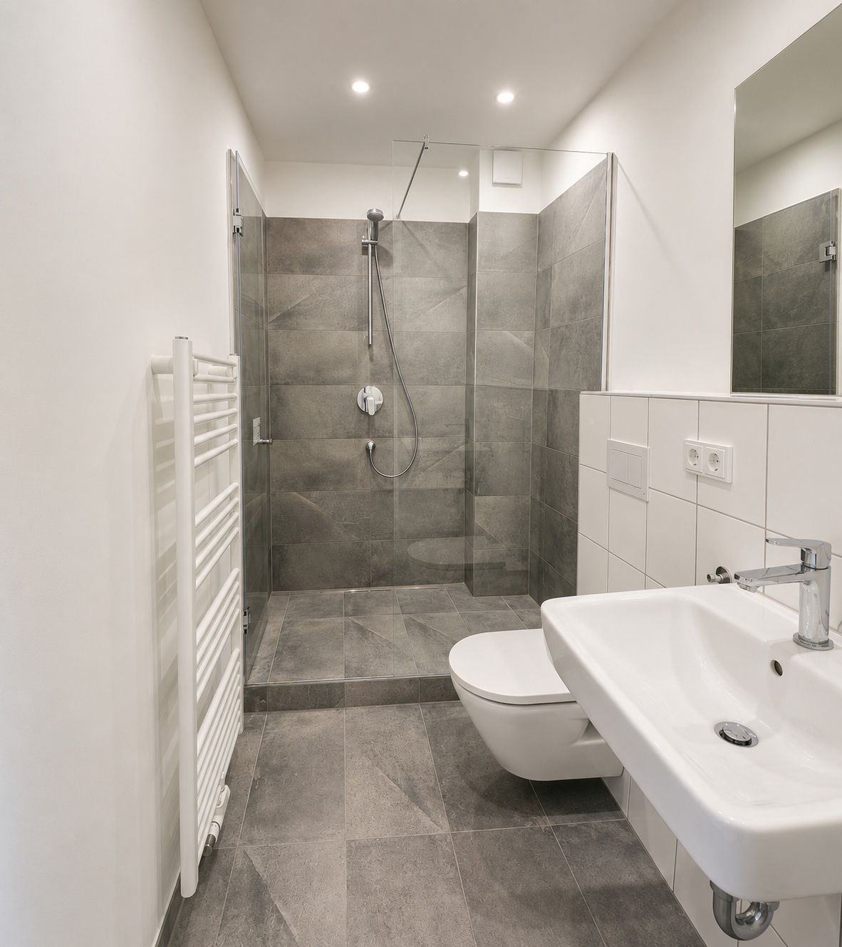 Modernes Badezimmer mit begehbarer Dusche, Waschbecken, WC und Handtuchheizkörper.
