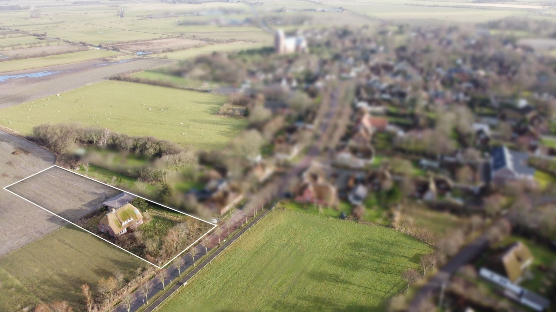 Luftaufnahme eines Hauses mit großem Garten, durch eine weiße Linie umrandet, in ländlicher Umgebung.
