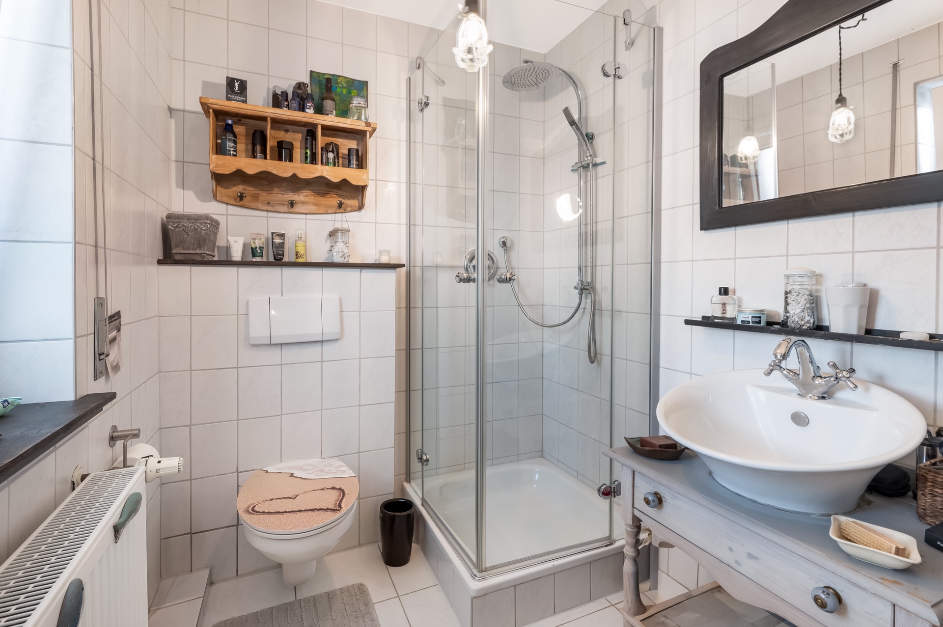 Modernes Badezimmer mit Eckdusche, rundem Waschbecken und Wandtoilette.