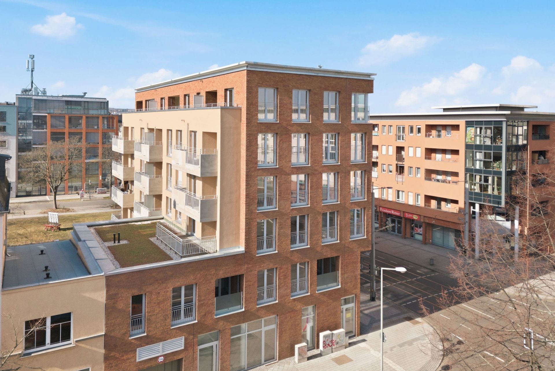 Mehrstöckiges Wohngebäude mit Balkonen und großen Fenstern in einer urbanen Umgebung.