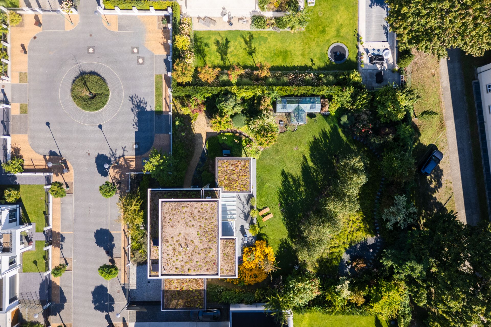 Luftaufnahme eines Wohnhauses mit begrüntem Dach und großem Garten.