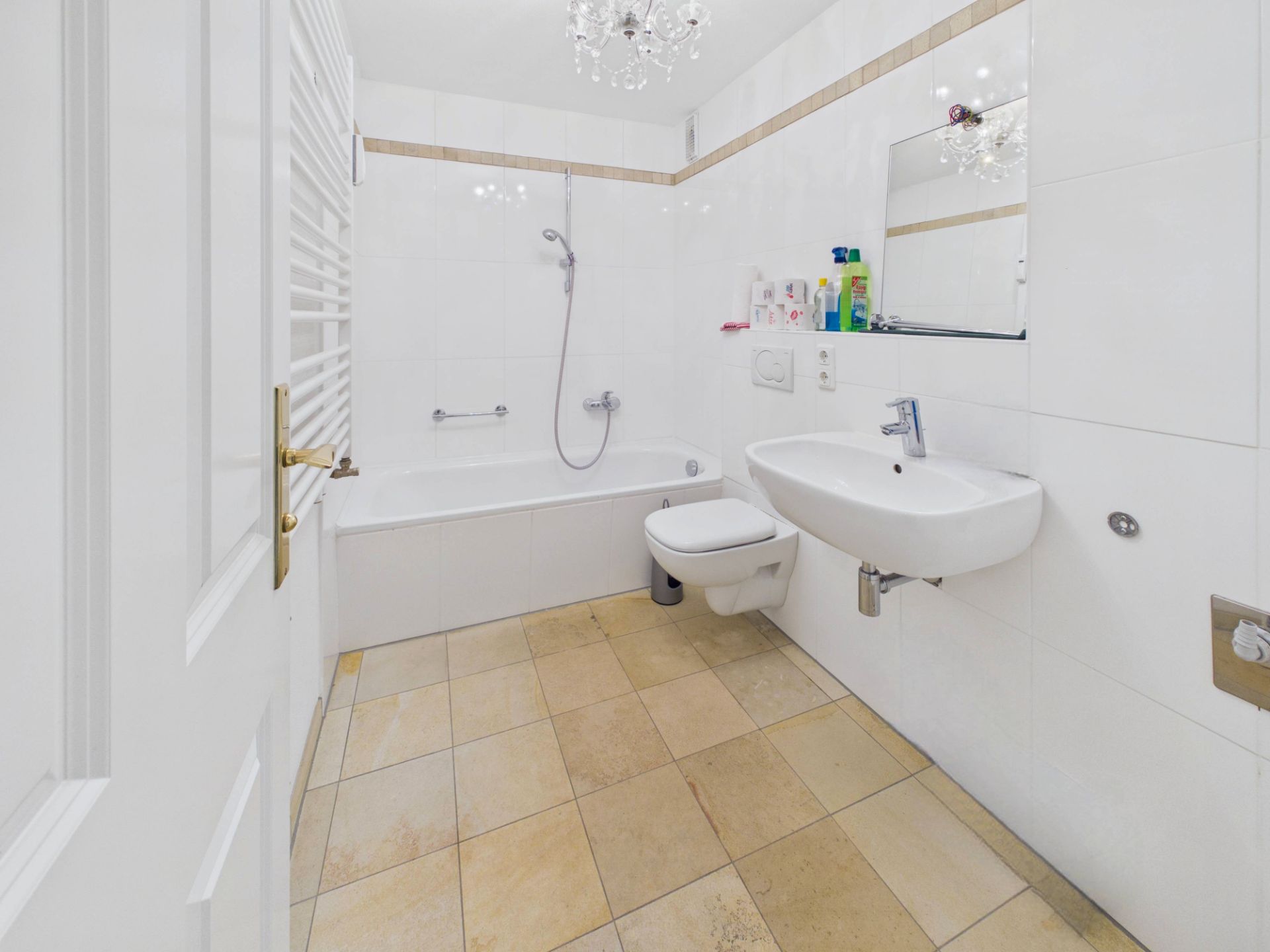 Helles Badezimmer mit Badewanne, Waschbecken, WC und Spiegel.