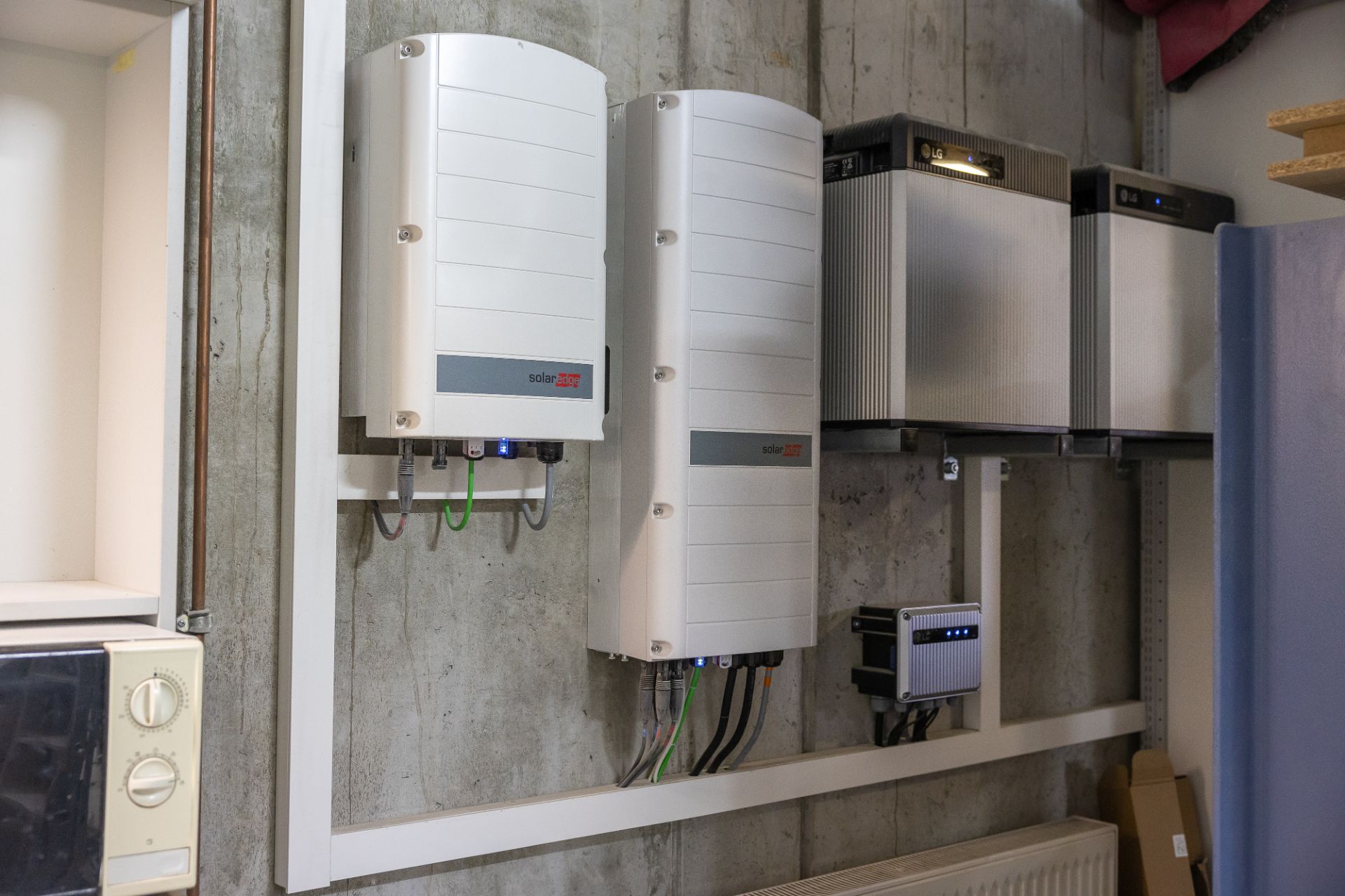 Mehrere elektrische Geräte und Steuerungen sind an einer Betonwand in einem Haus montiert.