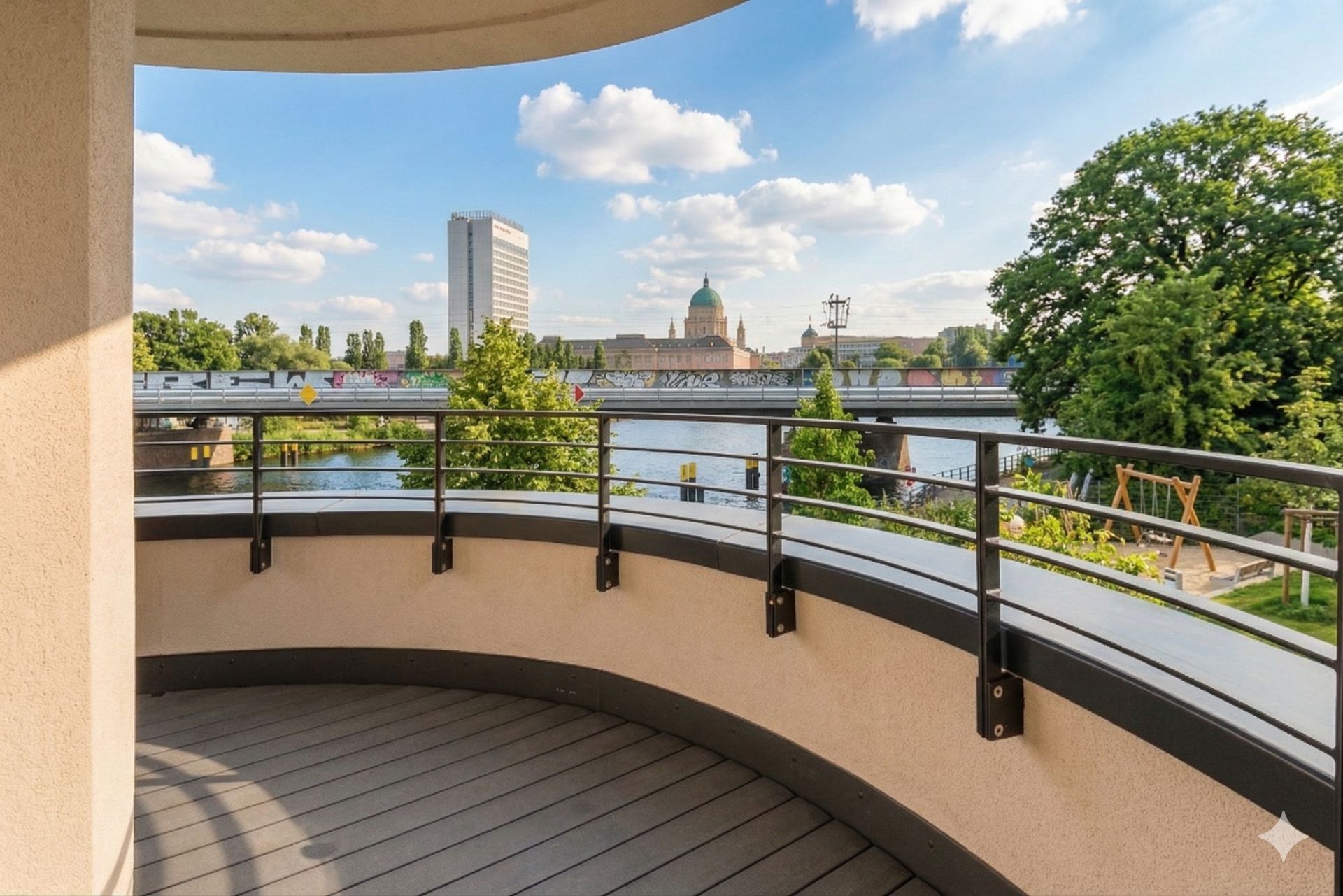 Runder Balkon mit Blick auf Fluss, Brücke, Bäume und Stadt mit mehreren Gebäuden im Hintergrund.