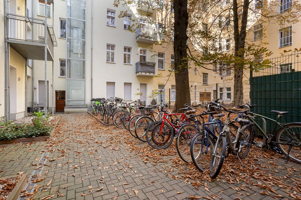 Innenhof mit mehreren geparkten Fahrrädern, Bäumen und umgebenden Wohngebäuden.