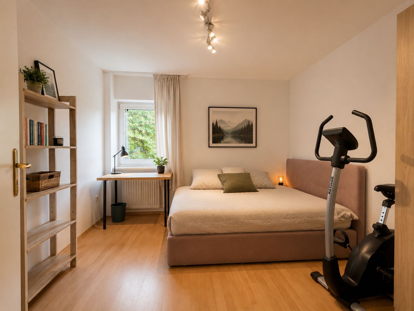 Helles Schlafzimmer mit Bett, Schreibtisch, Bücherregal und Heimtrainer auf Holzfußboden.
