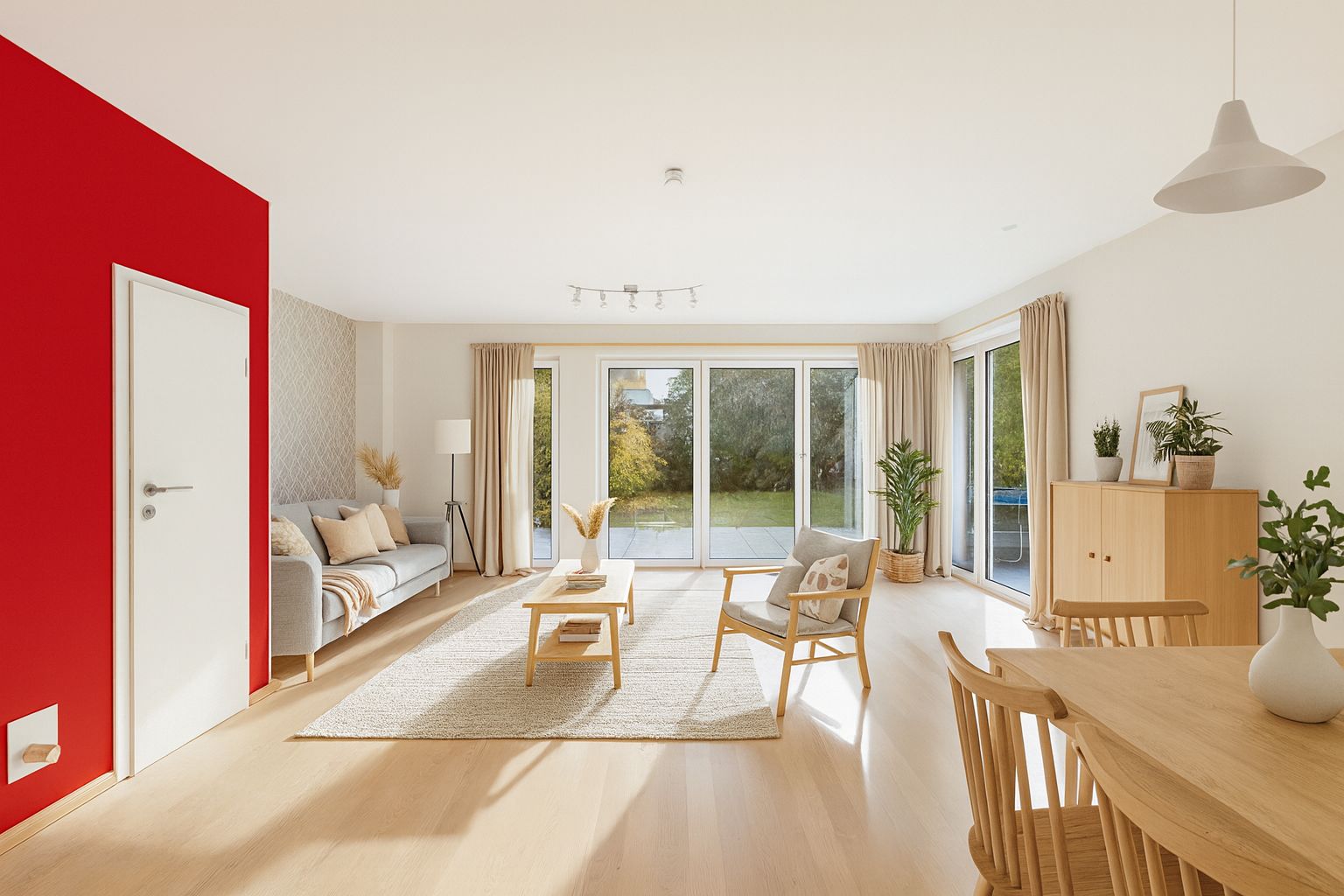 Helles Wohnzimmer mit roter Wand, Holzmöbeln, großem Fenster und Blick in den Garten.