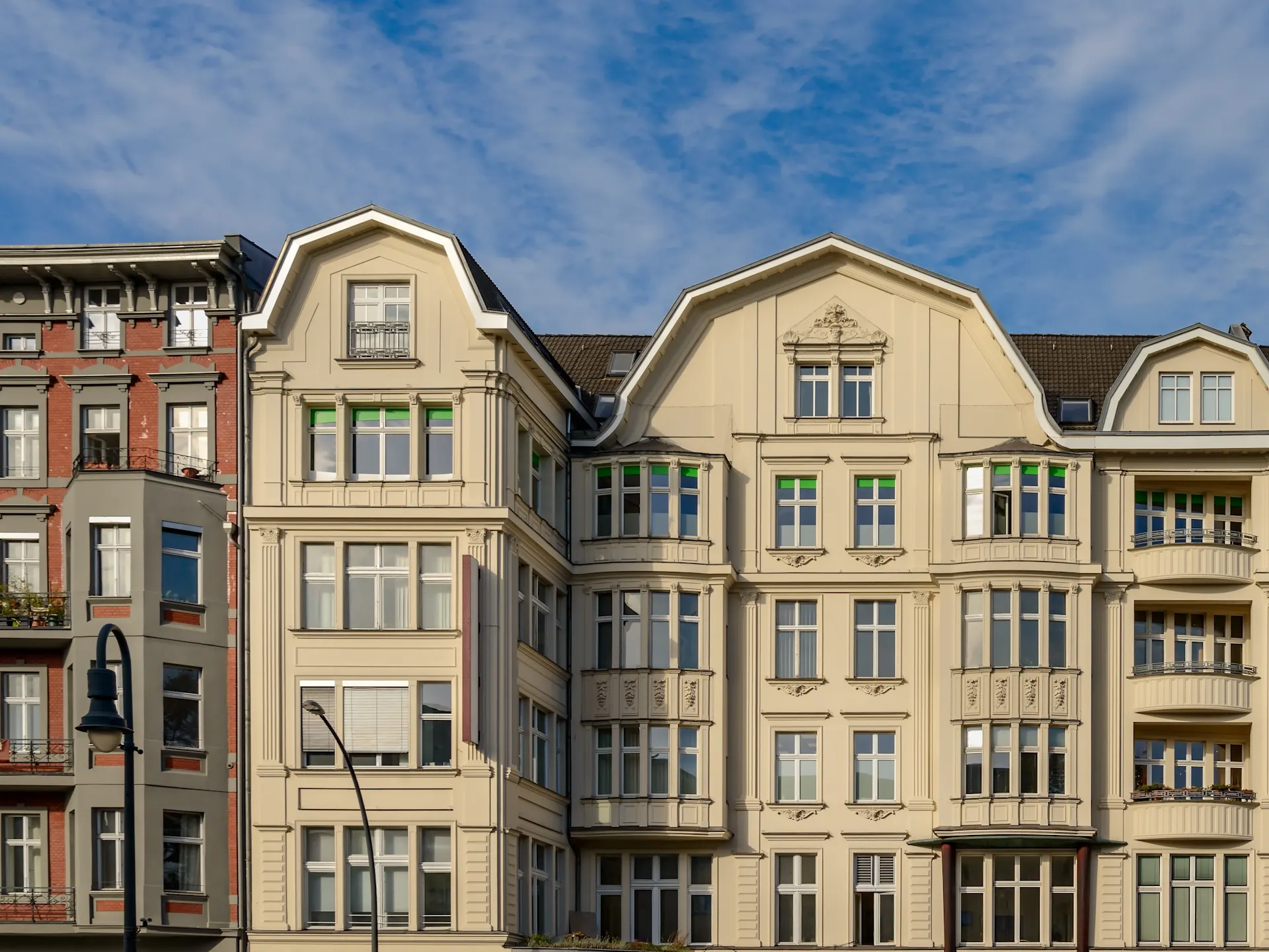 Fassade eines mehrstöckigen Wohnhauses mit vielen Fenstern und Balkonen.