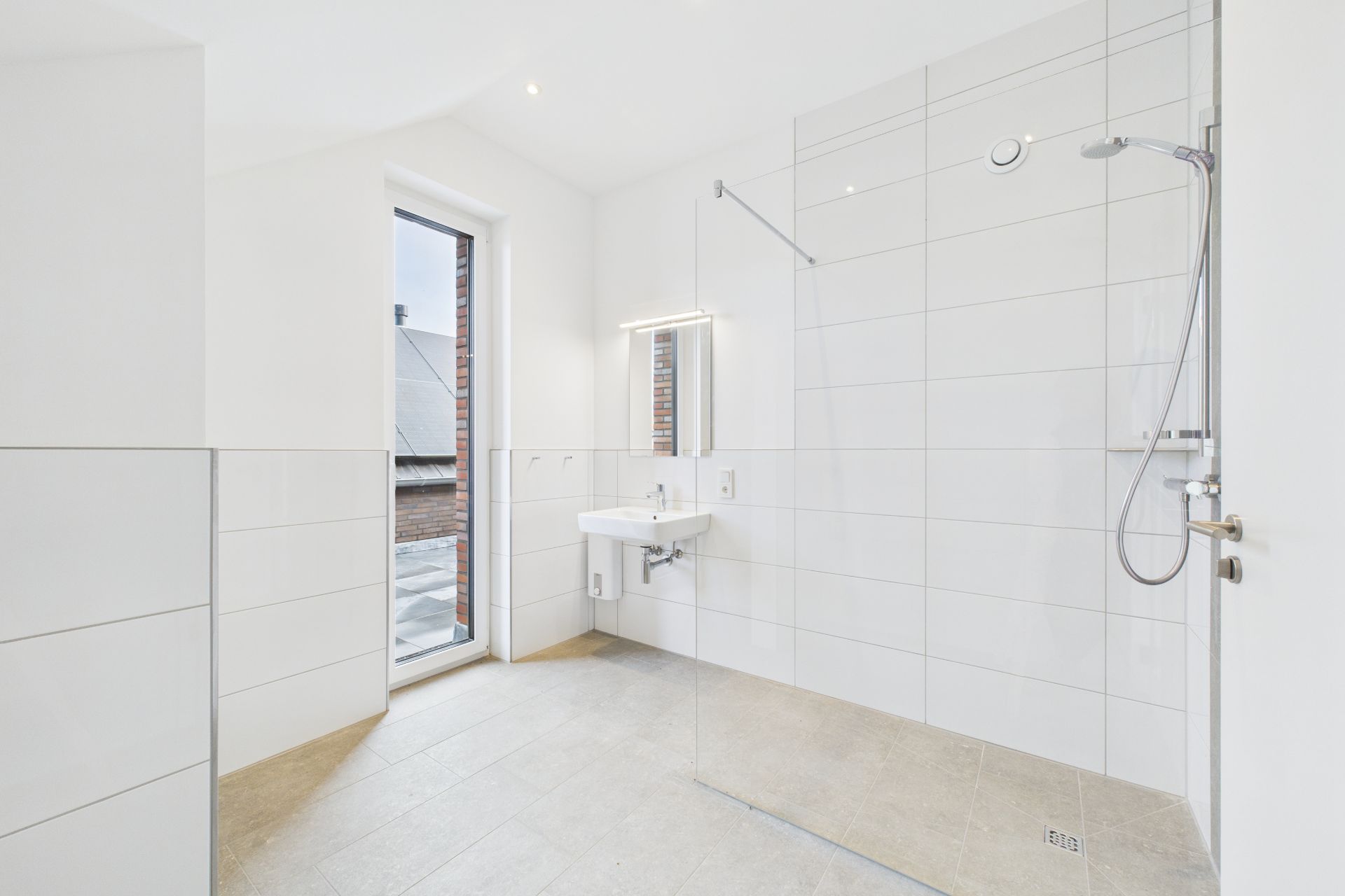 Modernes, helles Badezimmer mit Dusche, Waschbecken und bodentiefem Fenster.