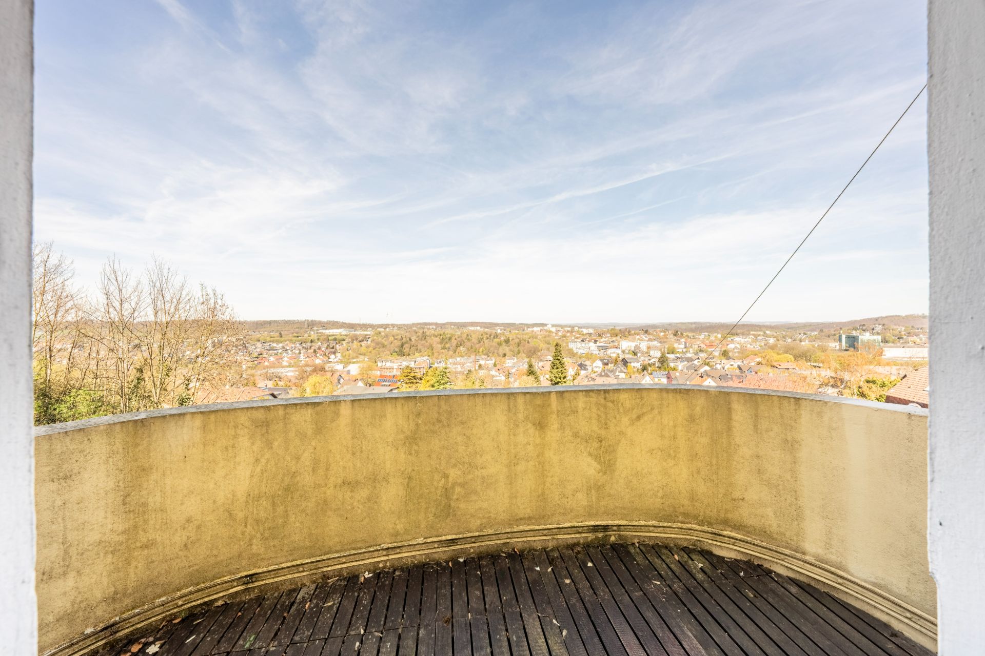 Balkon mit Holzfußboden und weitem Blick auf Stadt und Landschaft.