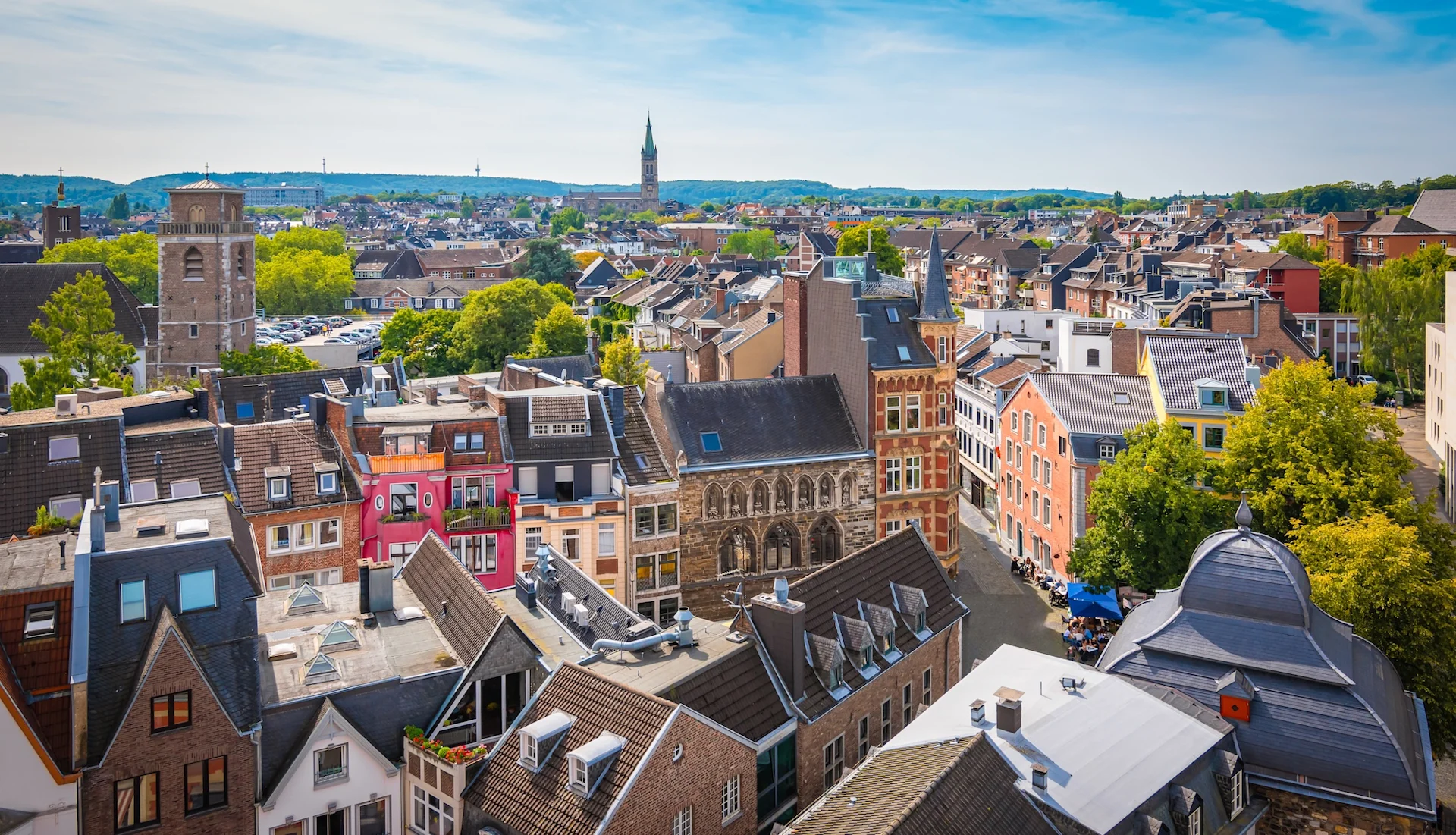 Blick über eine Altstadt mit bunten Häusern und Kirchtürmen bei klarem Himmel.