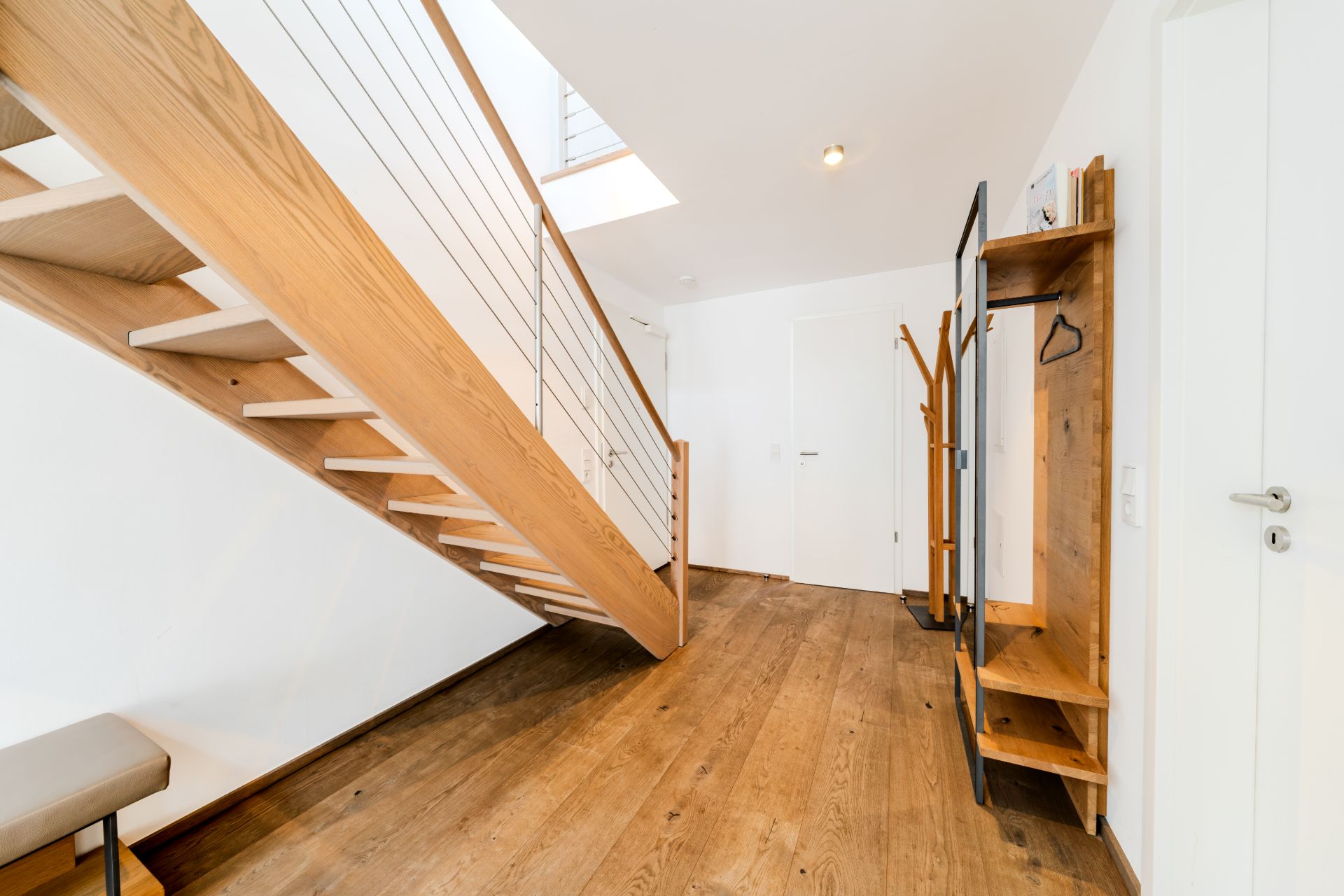 Moderner Flur mit Holztreppe, Garderobe und Holzboden.
