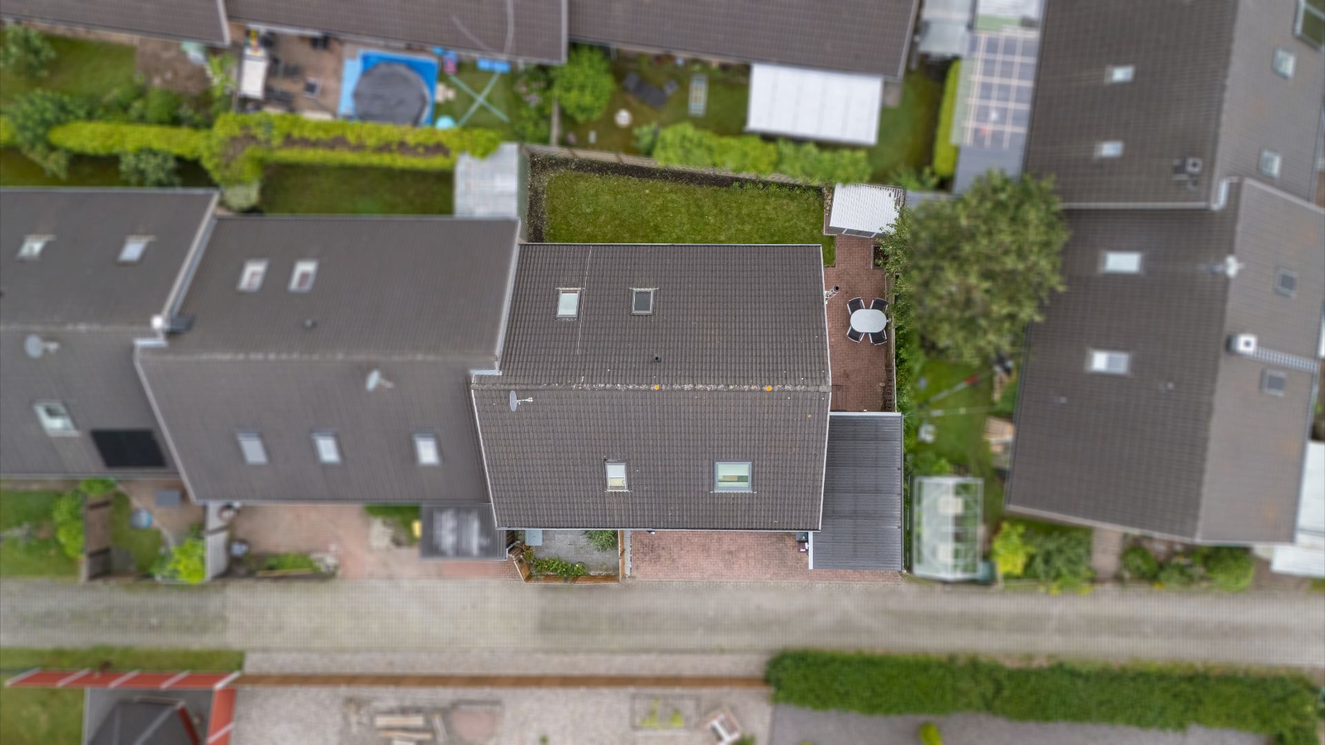 Luftaufnahme eines Wohnhauses mit Garten, Terrasse und Nebengebäuden.